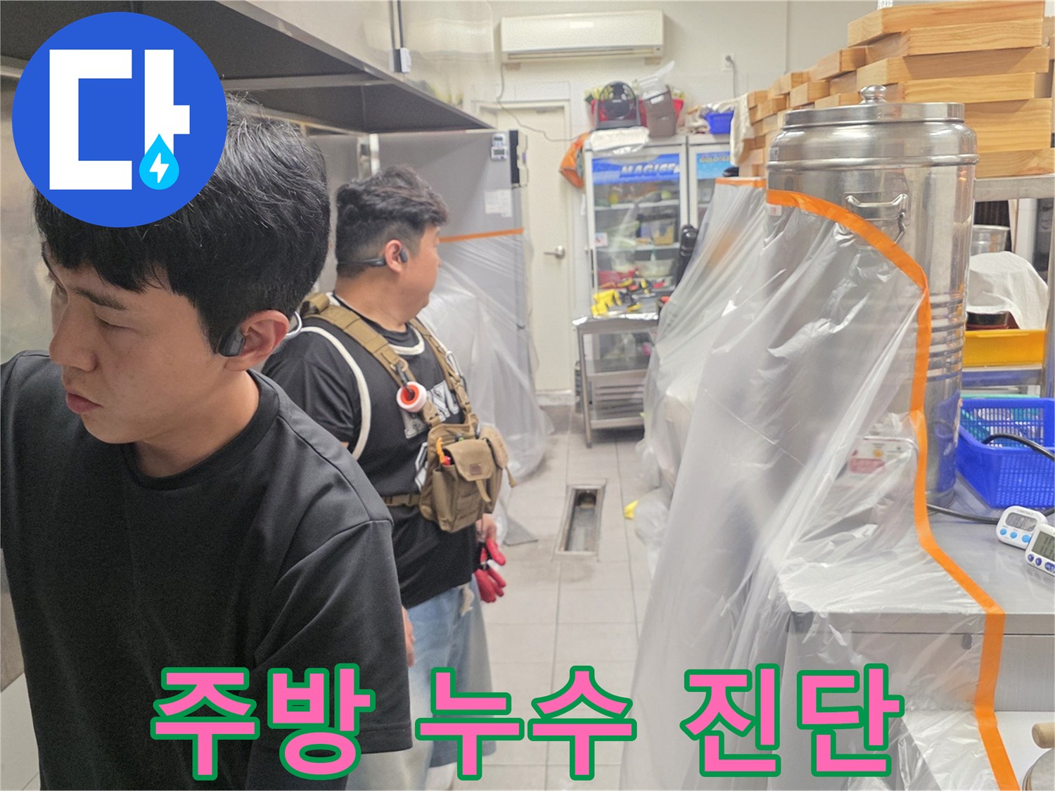 식당 조리 구역에서 배관 문제를 조사하는 엔지니어의 모습입니다.