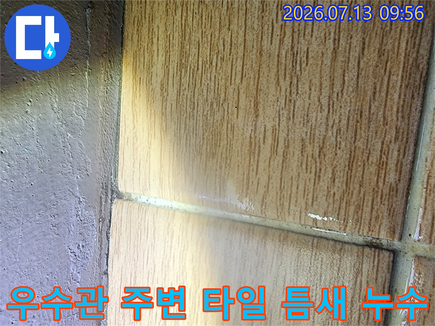 우수관과 바닥 타일의 경계면을 상세히 촬영한 사진