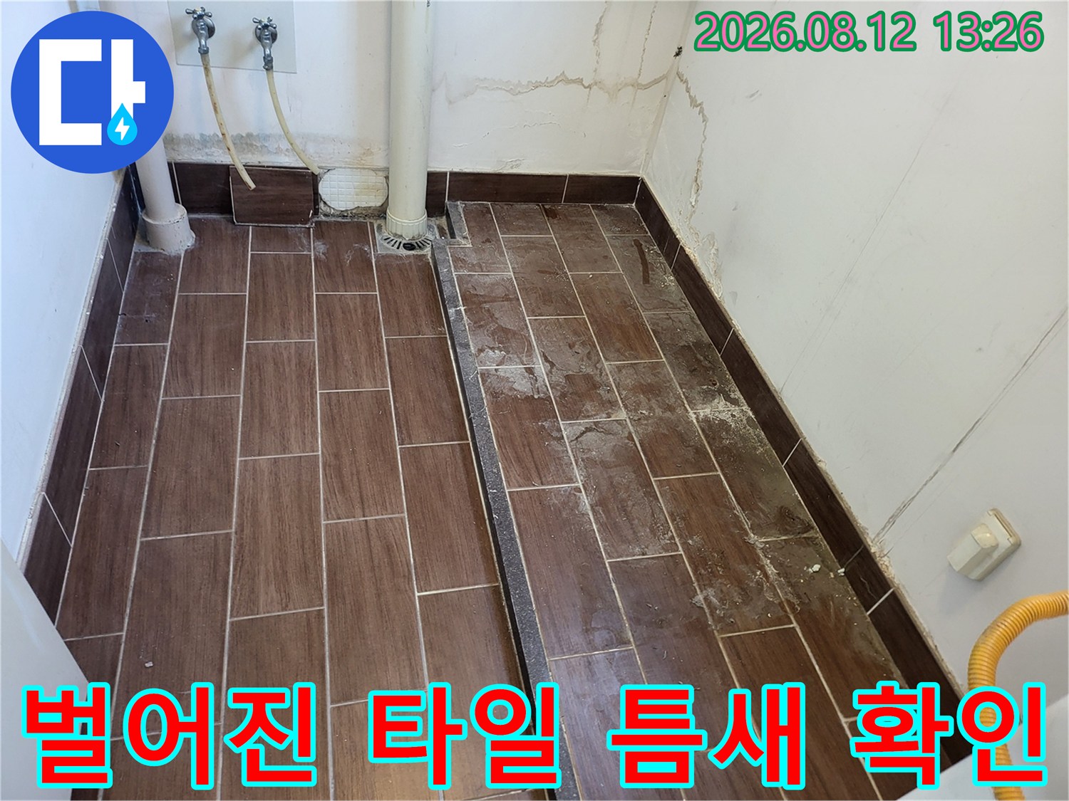 물샘 흔적이 보이는 세탁실 바닥 타일과 벽면 하단