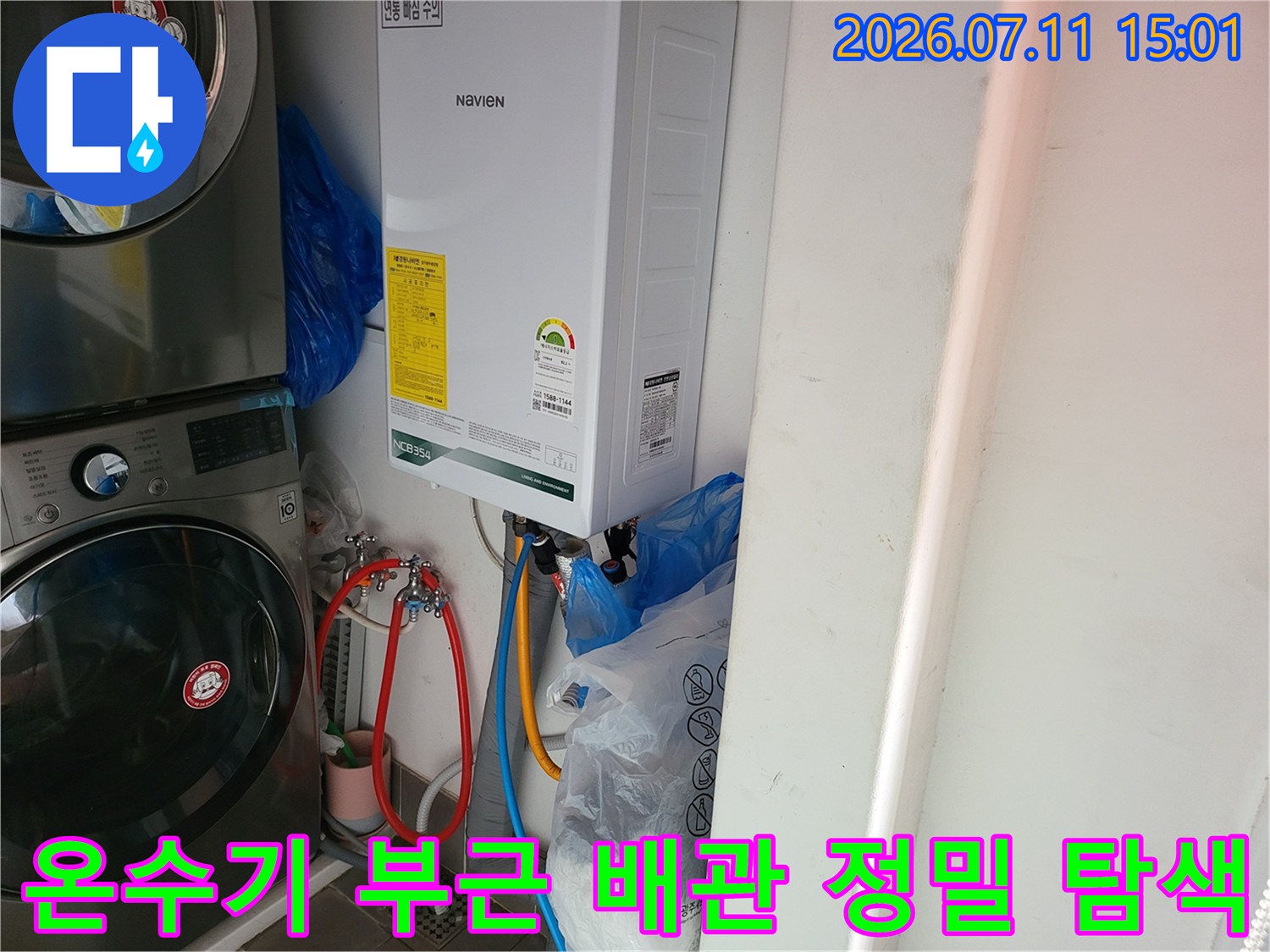 세탁실 내 온수기와 연결된 다양한 배관들의 누수 여부를 세심하게 점검하는 모습