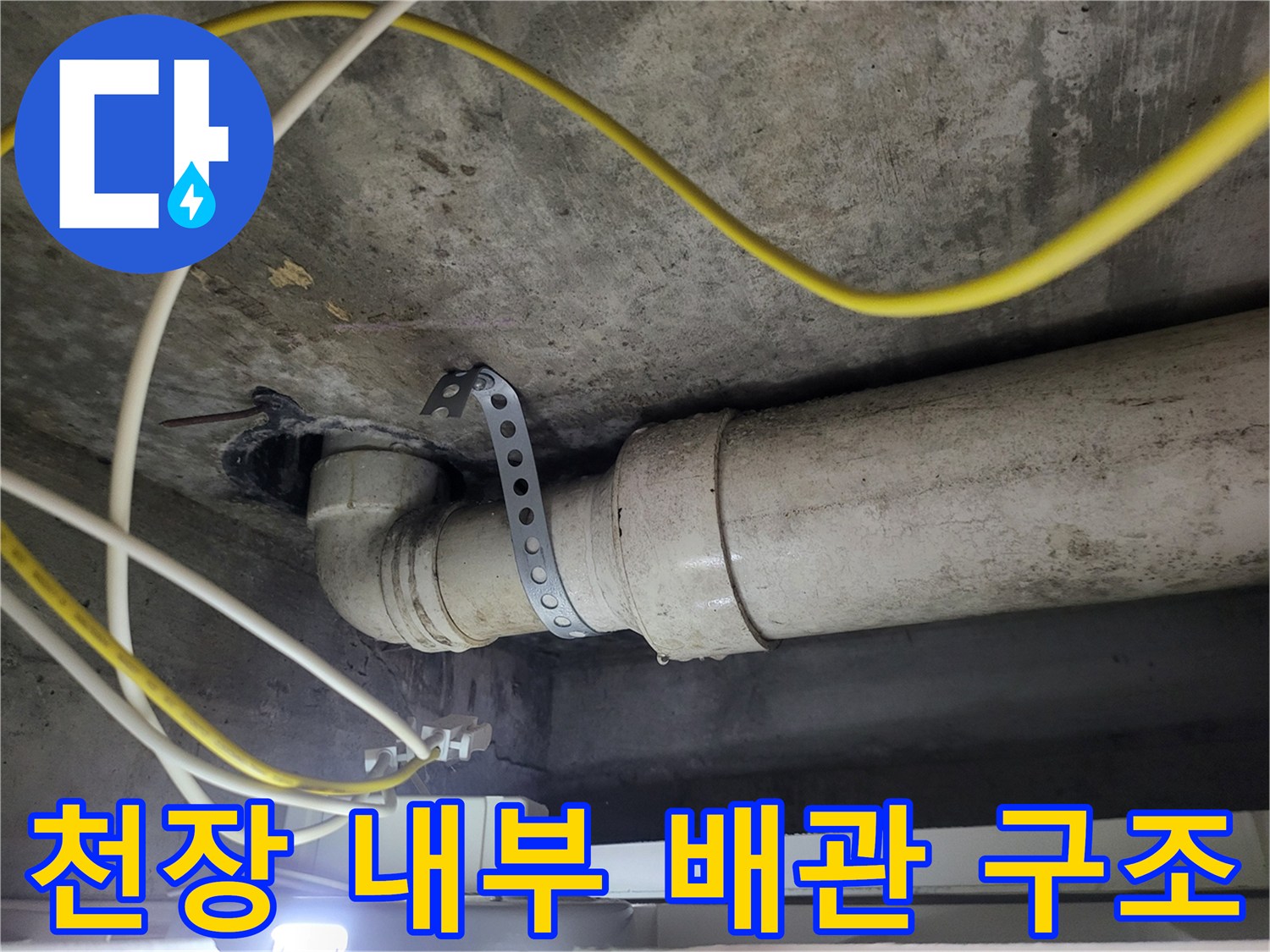콘크리트 천장에 고정된 하수 배관과 전선