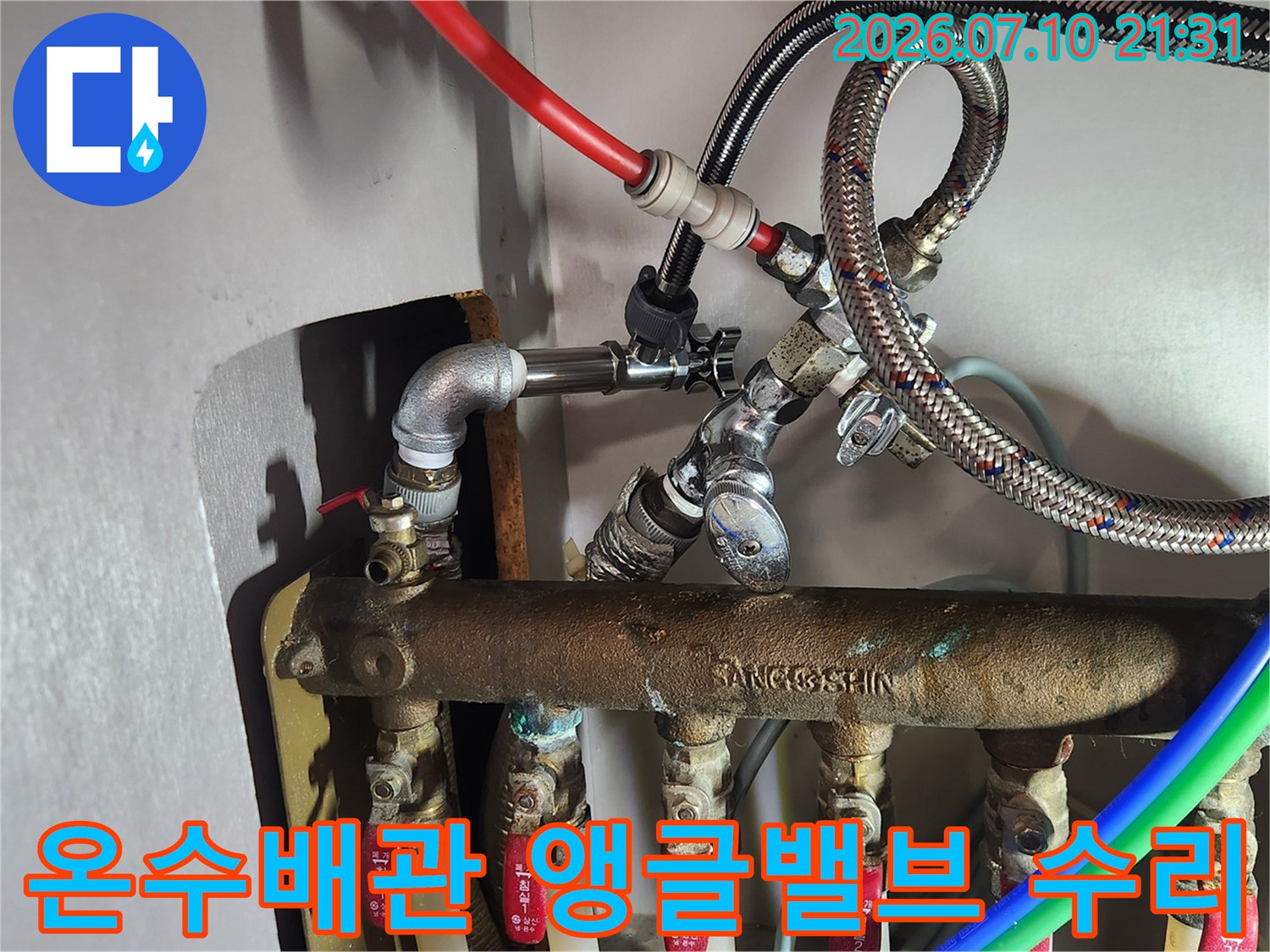거무스름한 배관 위에 설치된 온수용 앵글밸브와 연결 호스 점검 장면