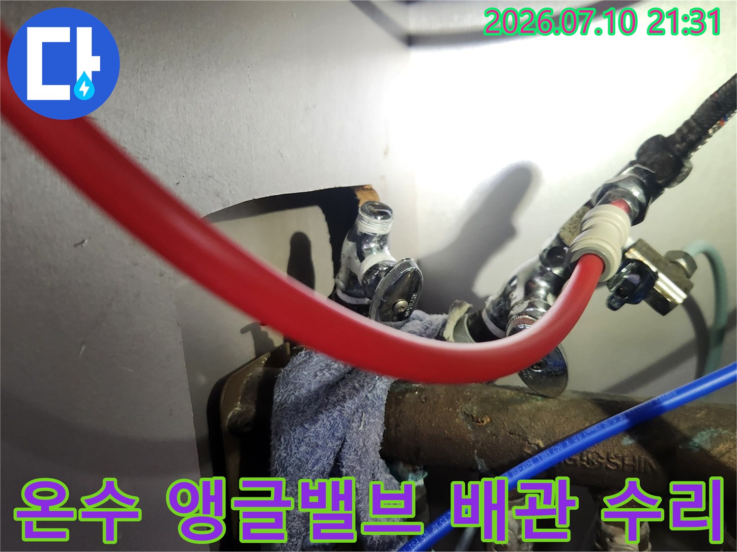 노출된 온수 배관과 고압 호스 연결 부위의 누수 보수 작업 현장