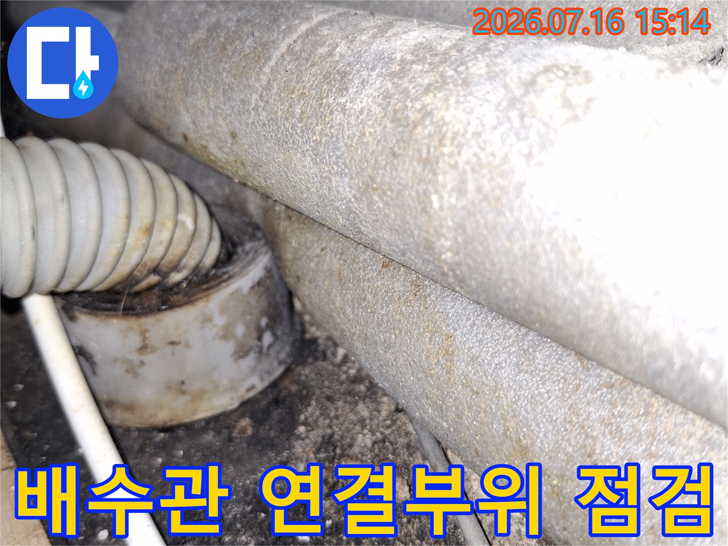 배수관 연결 부위와 유연한 배수 호스가 노출된 천장 내부 모습