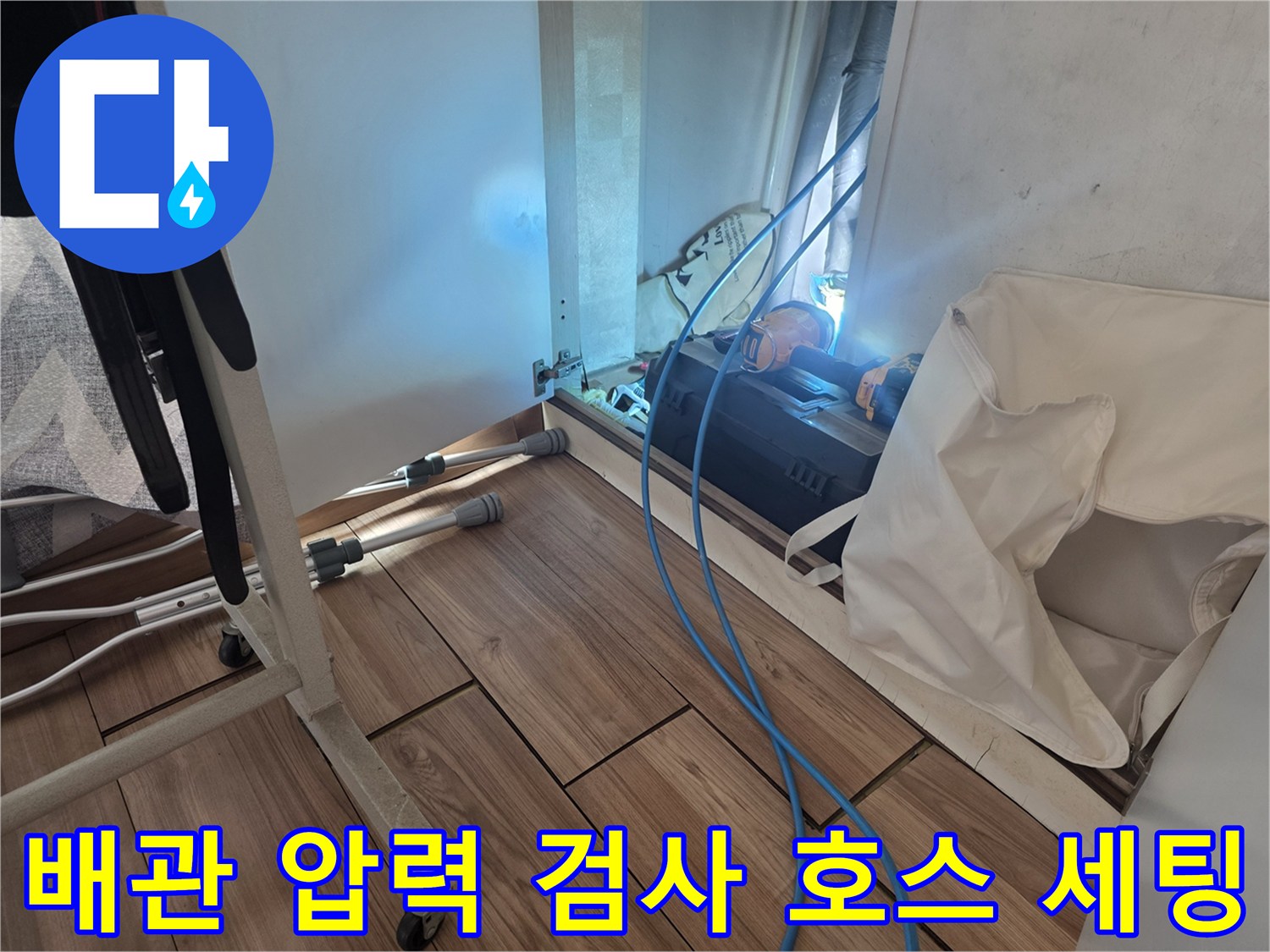 바닥에 설치된 배관 연결 부위와 테스트용 파란색 호스 라인