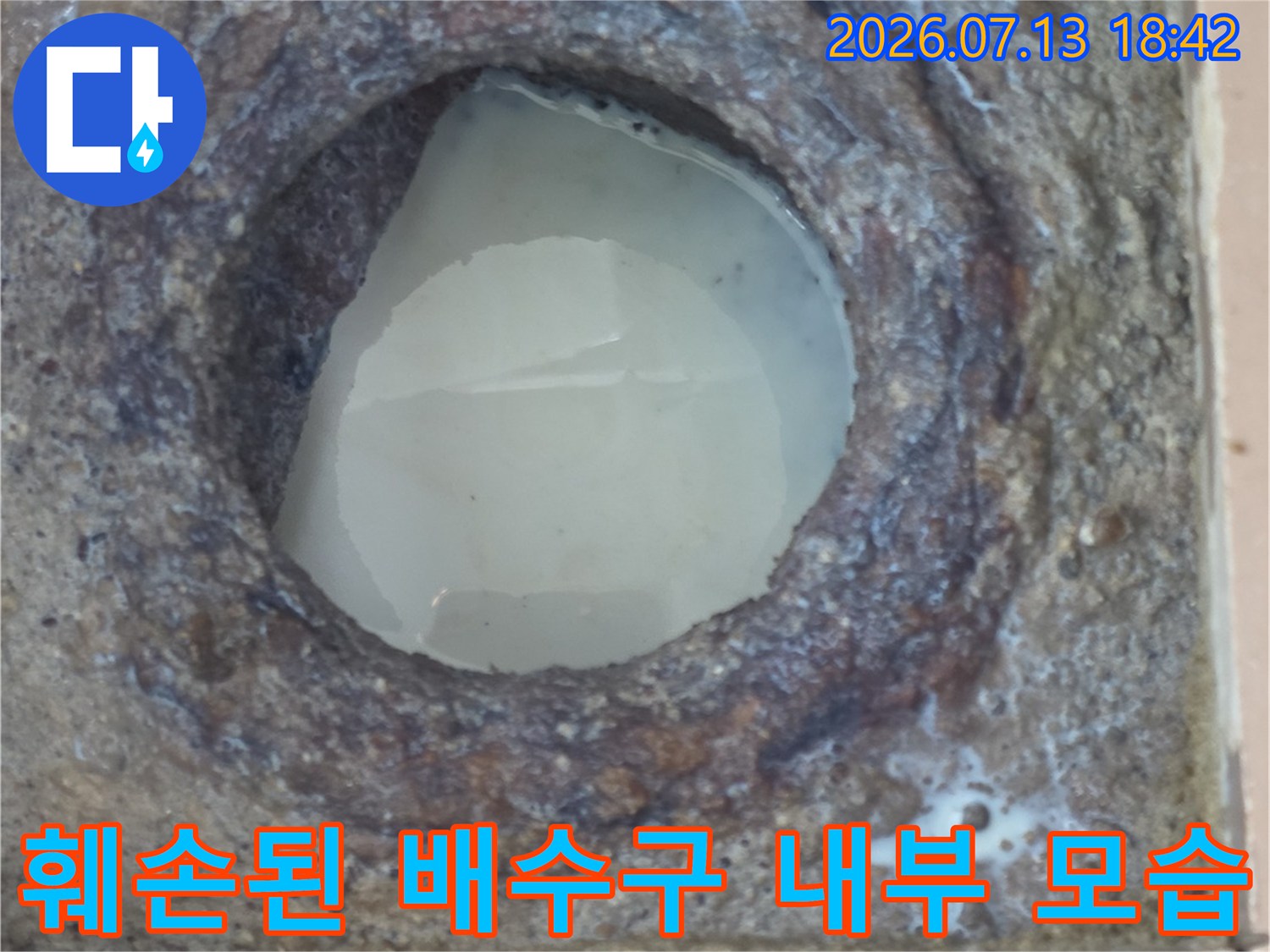 거칠게 부식된 세탁실 하수관 입구 촬영 사진