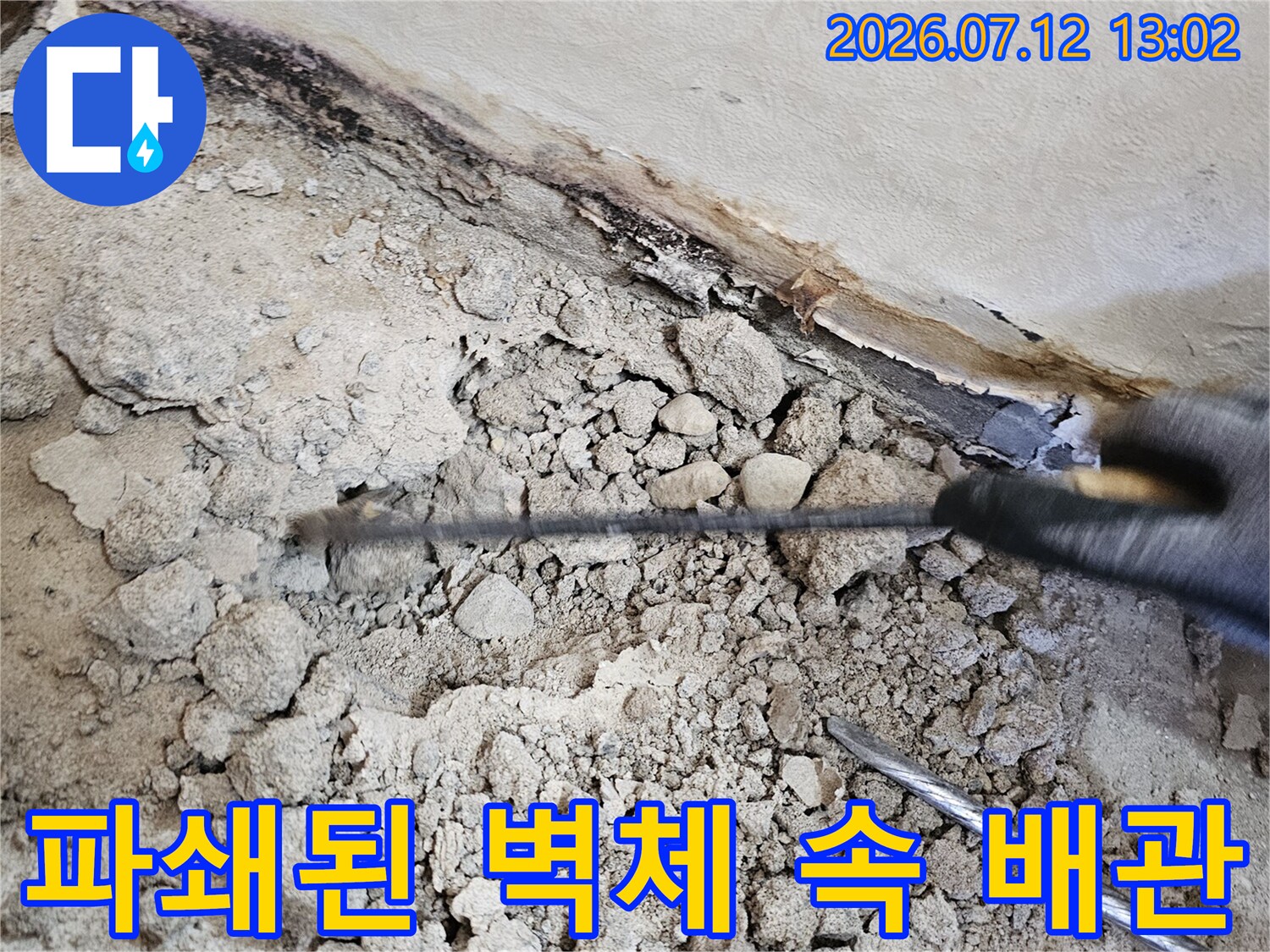 망치와 장비를 사용하여 파손된 구간을 드러내는 공사 현장