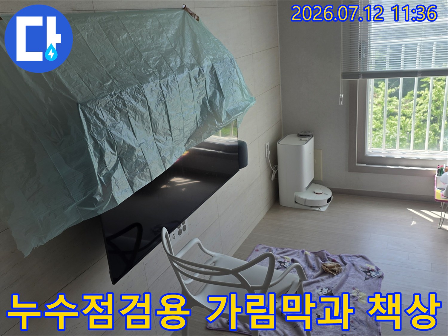 누수 점검 중 작업 공간을 보호하기 위해 설치한 비닐 가림막과 테이블