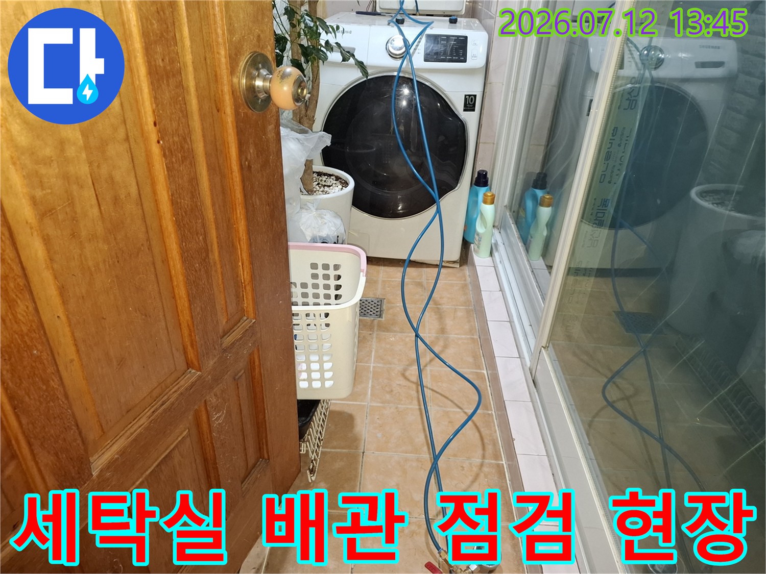세탁기 옆 바닥에 노출된 파란색 배관과 장비가 있는 누수 탐지 현장