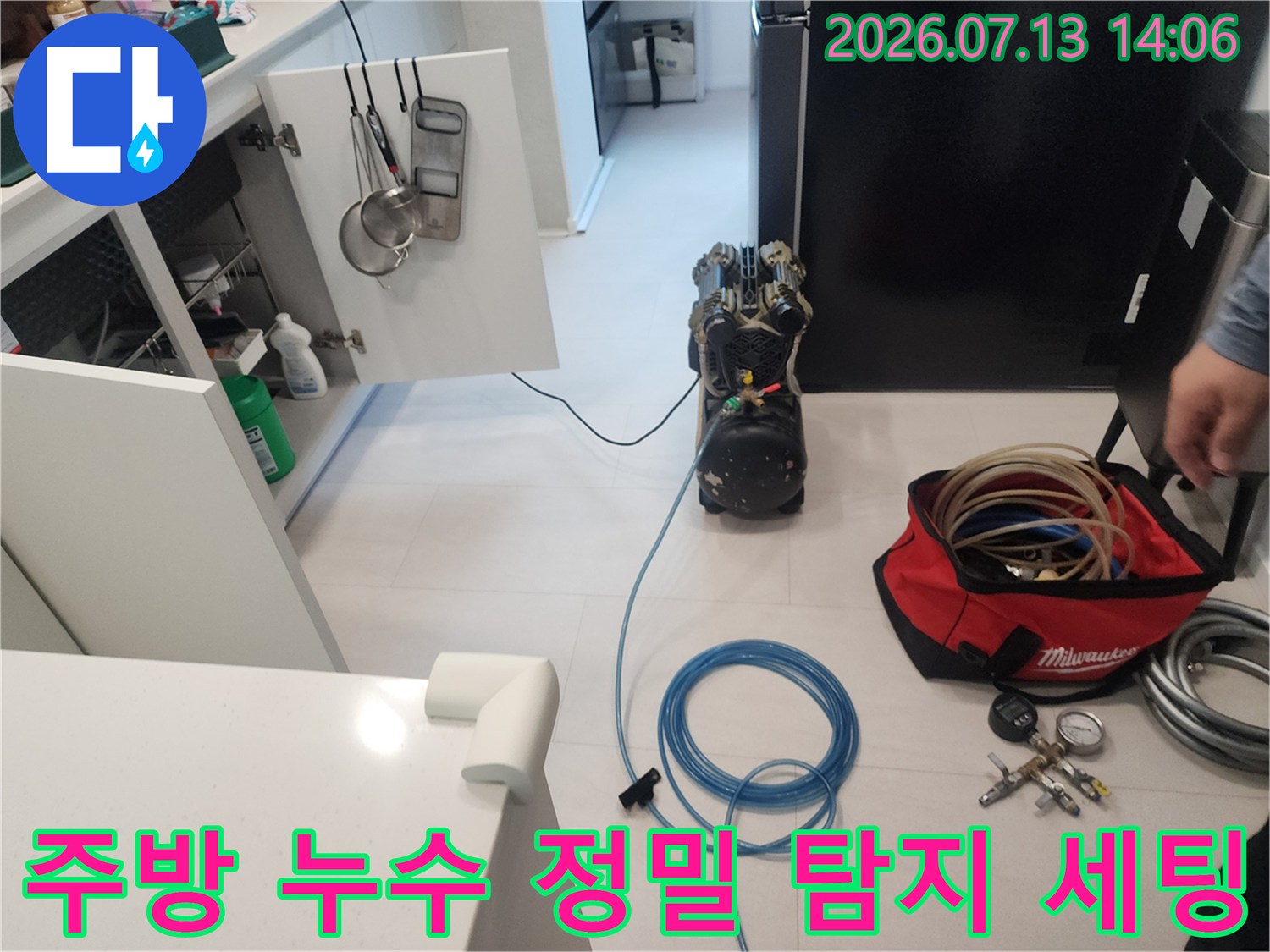 싱크대 하부장 앞에 설치된 파란색 압력 호스와 가압 측정 장치들