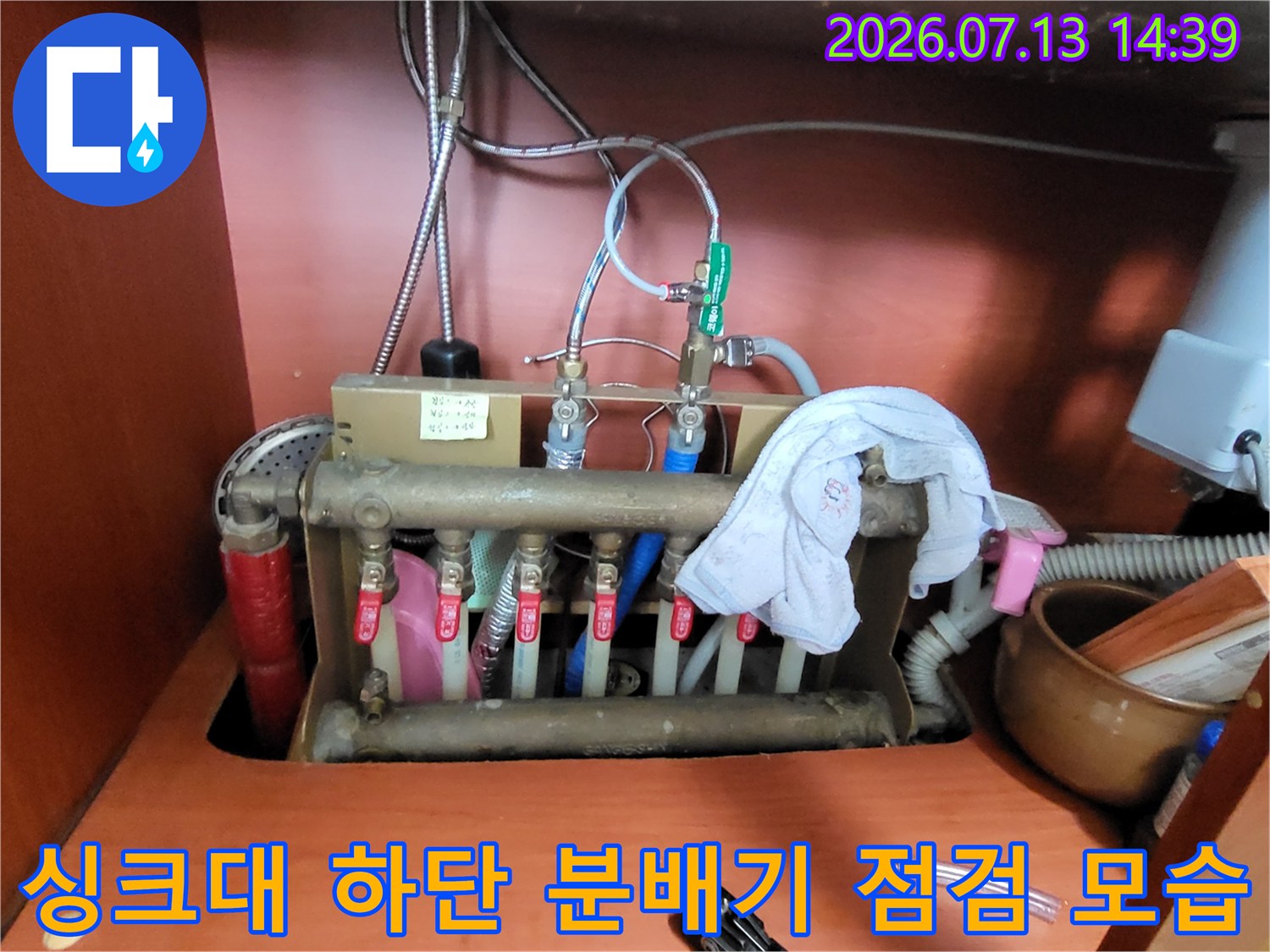 싱크대 아래 설치된 보일러 난방 분배기와 연결 배관들-누수 점검 중인 상태