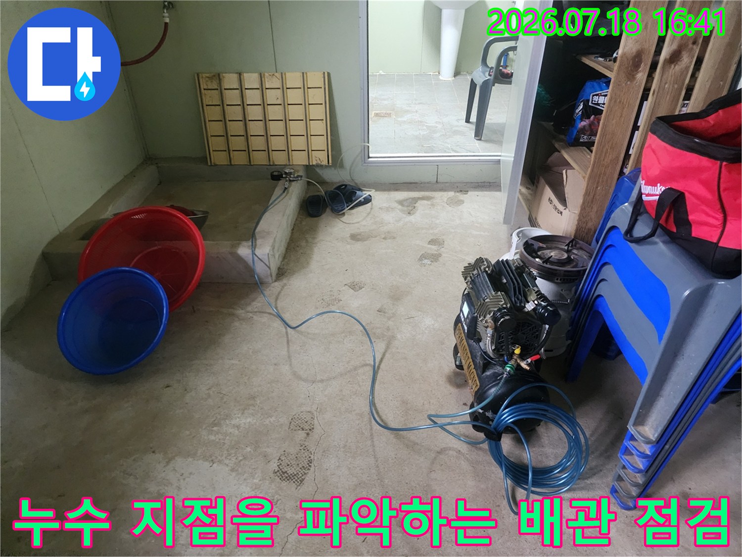 파란색 호스와 펌프 장치가 연결된 누수 점검 현장 모습