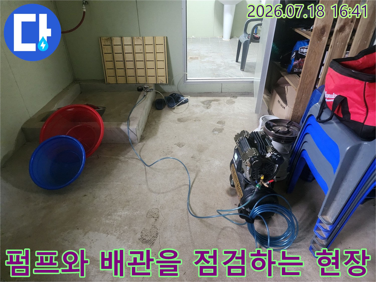 펌프와 호스가 연결된 배관 시스템과 작업용 대야를 배치한 누수 탐지 현장