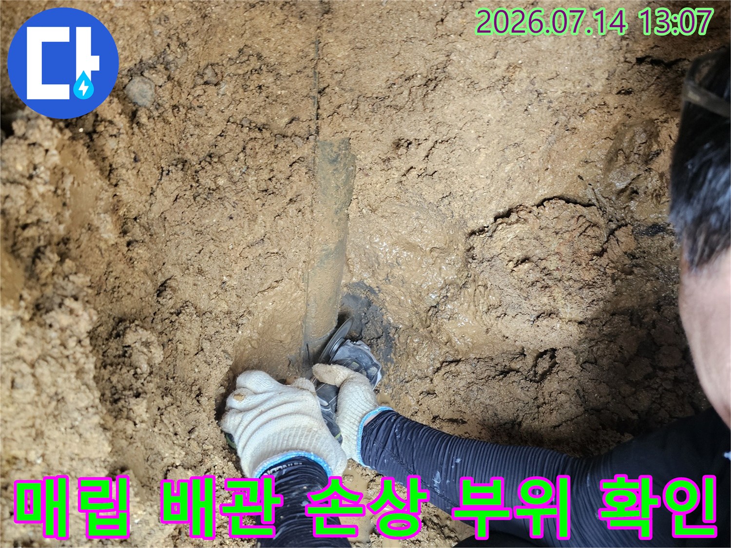 노출된 젖은 토양과 파손된 수도 배관 연결부의 보수 현장