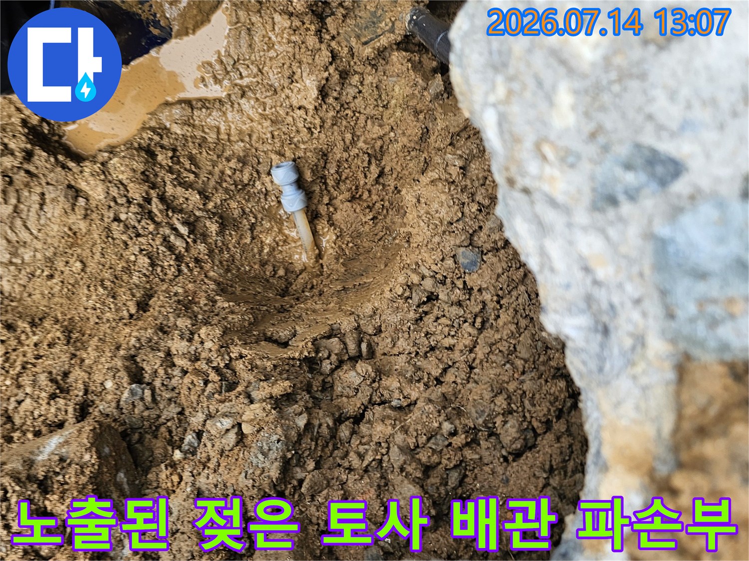 배관 파손으로 인해 물이 고여 있는 젖은 흙과 노출된 지표면 모습