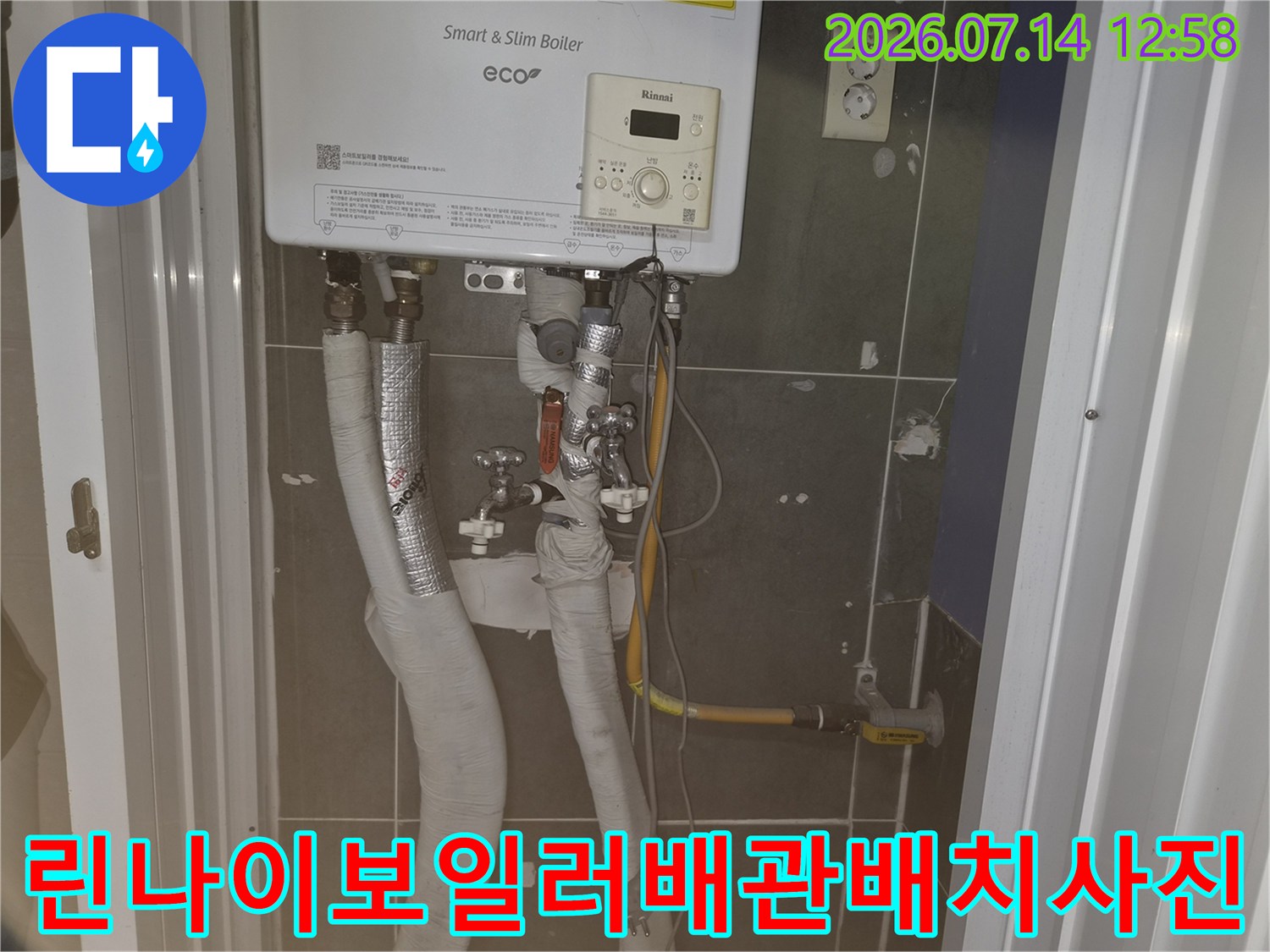 벽면에 설치된 보일러와 그 아래로 연결된 여러 가닥의 배관들 모습