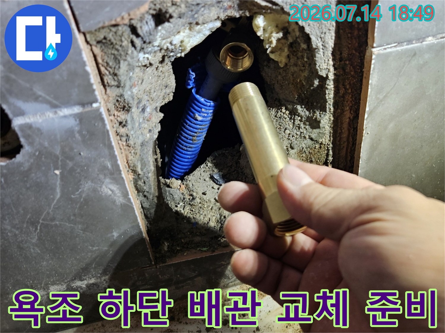 파란색 유연한 파이프와 새 수전 소모품을 들고 누수 지점을 점검하는 현장