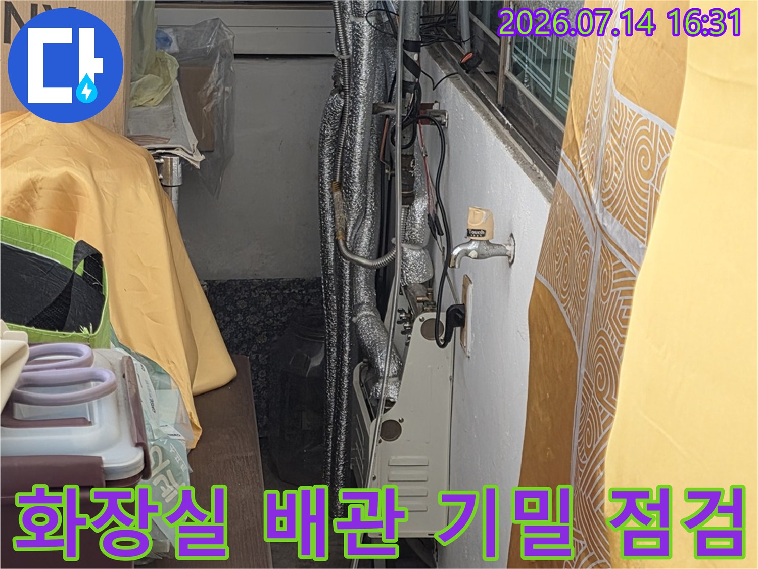 화장실 천장 안쪽의 배관과 압력 테스트를 위한 장비가 설치된 모습