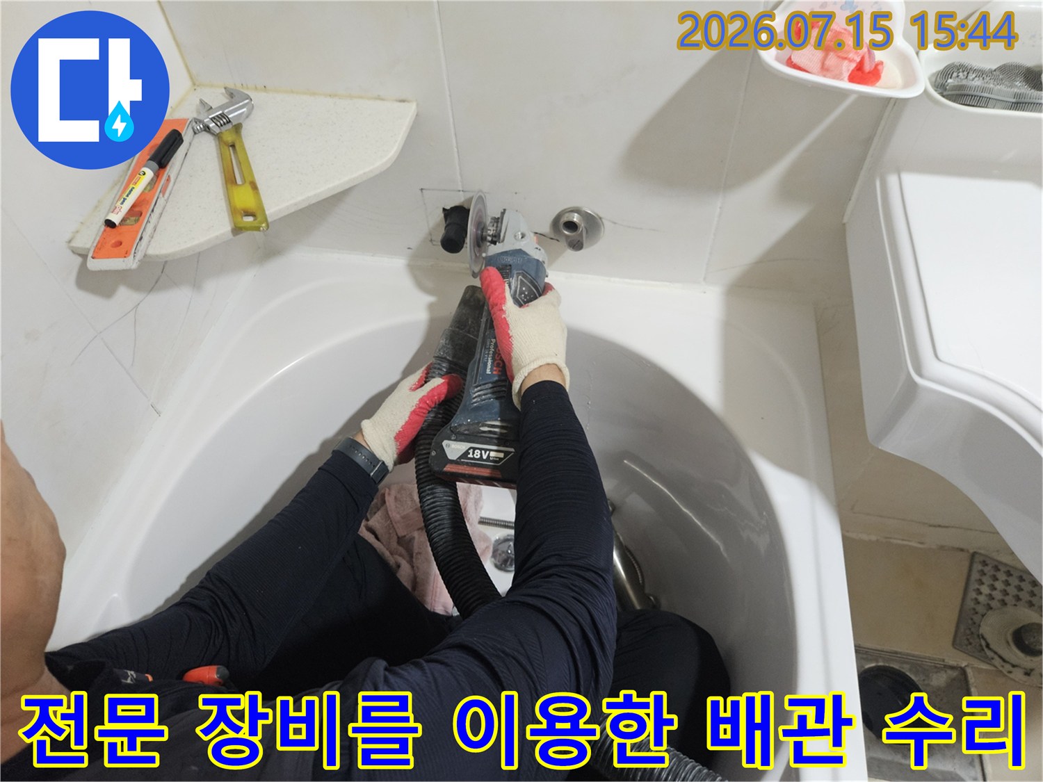 세면대 아래 노출된 파손 배관을 점검하고 교체하는 공사 모습