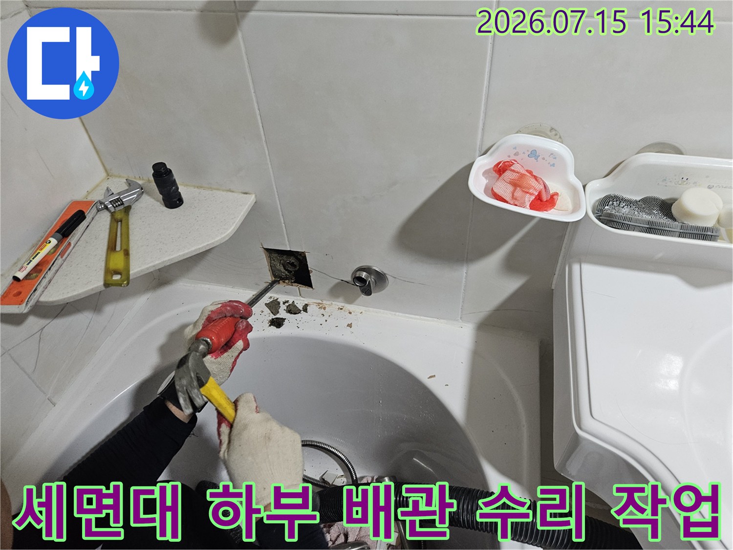 세면대 아래쪽 노후된 배관을 전용 공구로 절단하고 교체하는 누수 보수 현장