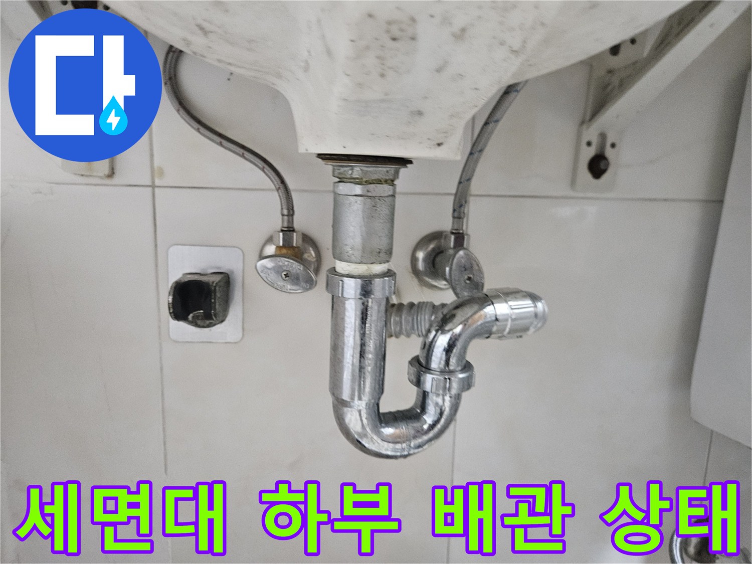세면대-하단에-연결된-금속재질의-배수-트랩과-급수-호스-점검-사진