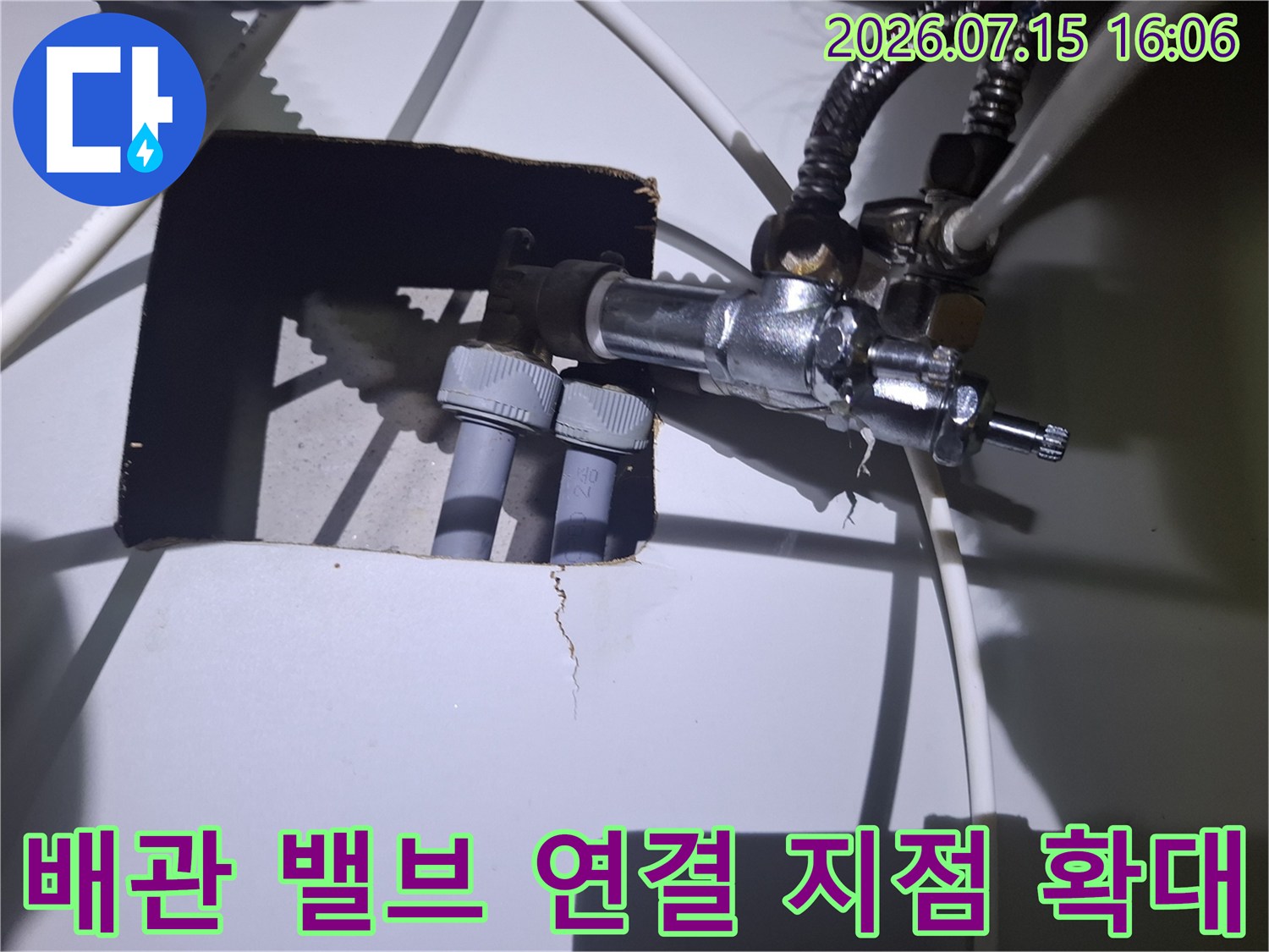 금속 소재의 배관 밸브와 회색 플라스틱 관이 체결된 모습-누수 점검 부위