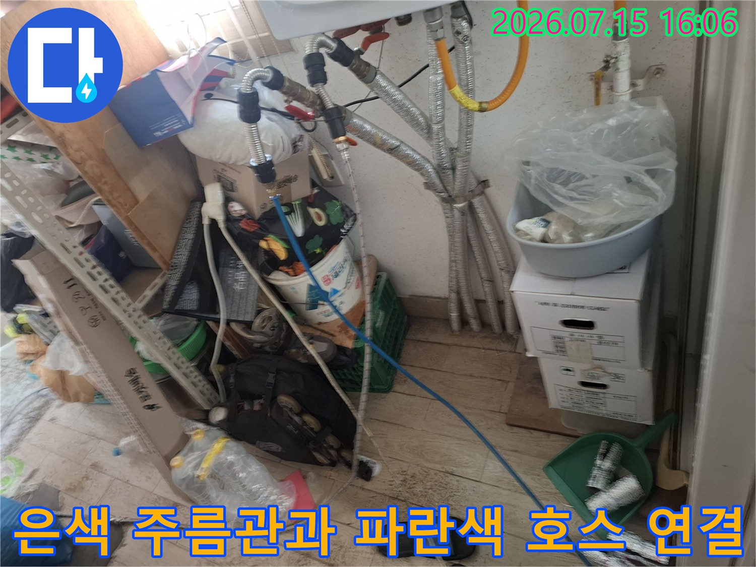 보일러 본체에서 내려오는 은색 금속 배관-파란색 플라스틱 관이 교차되어 연결된 모습