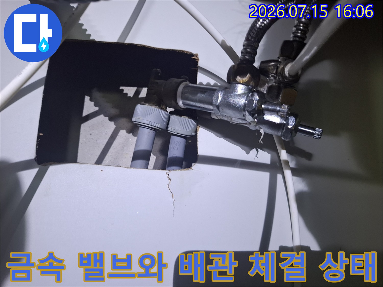 은색 금속 밸브와 회색의 두꺼운 배관이 연결된 보일러 하부 사진