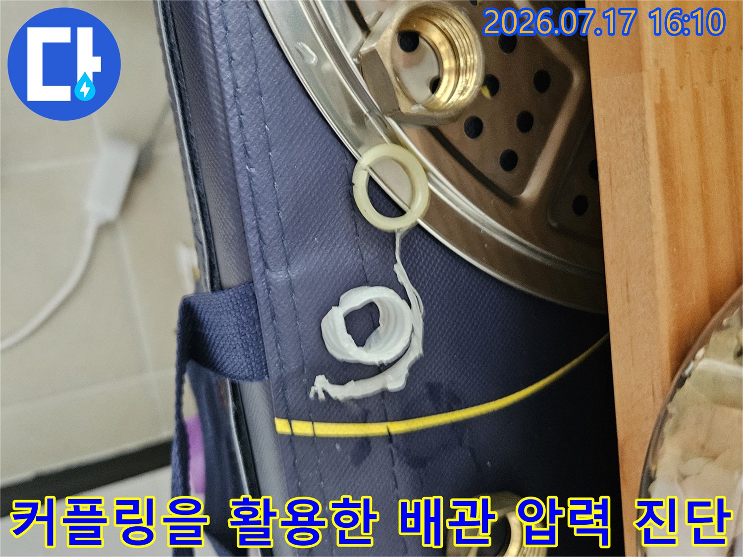 공압 테스트를 위해 수전 연결부에 호스와 커플러를 장착하여 기밀 상태를 점검하는 모습