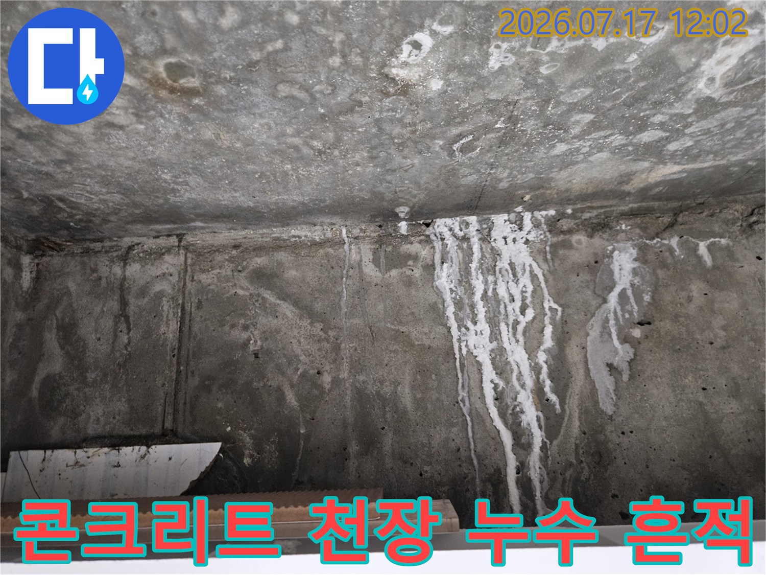 하얀색 수직 줄무늬 형태의 석회성분 결합과 물자국이 섞여 있는 화장실 천장 콘크리트면