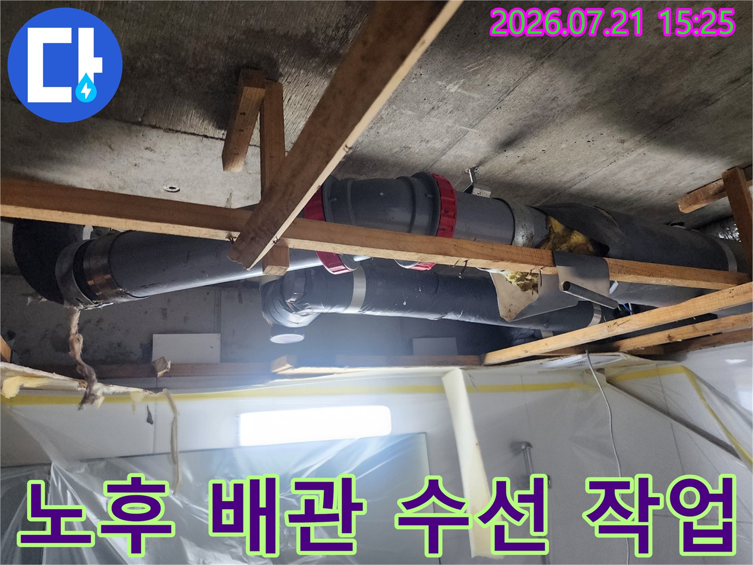 화장실 천장 내부의 노후된 오수 배관을 절단하고 새 부속으로 교체하는 장면