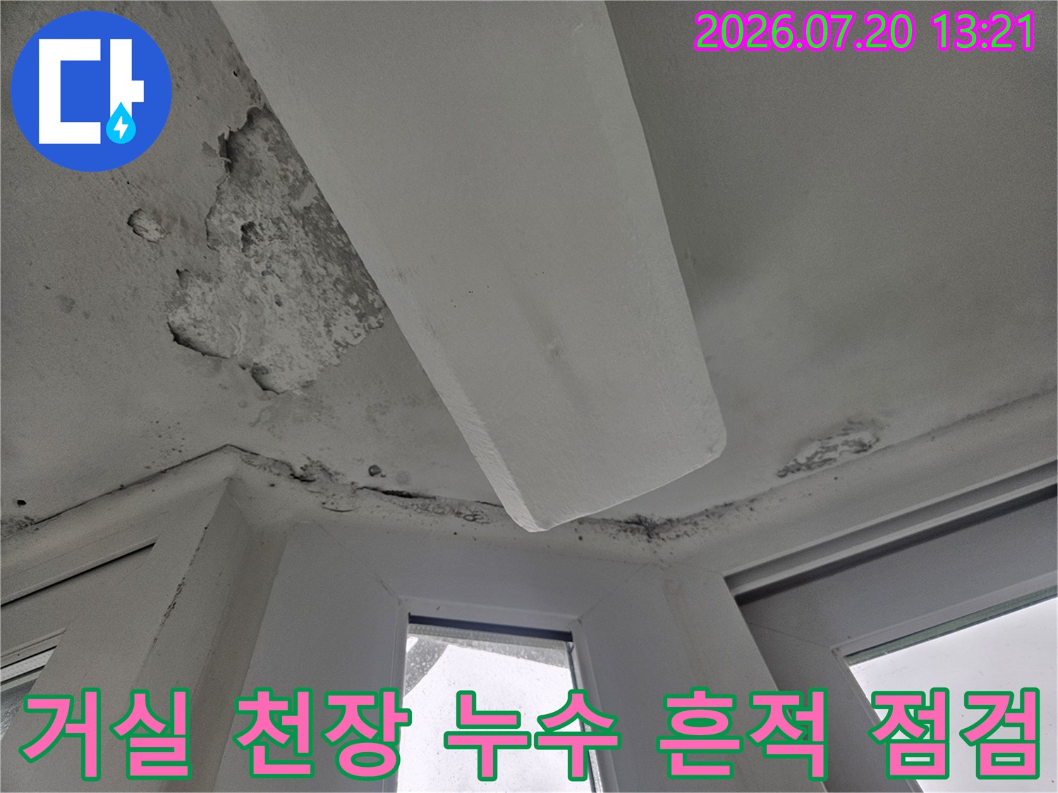 아파트 거실 천장의 석고보드 파손과 물에 의한 오염 흔적이 보이는 모습