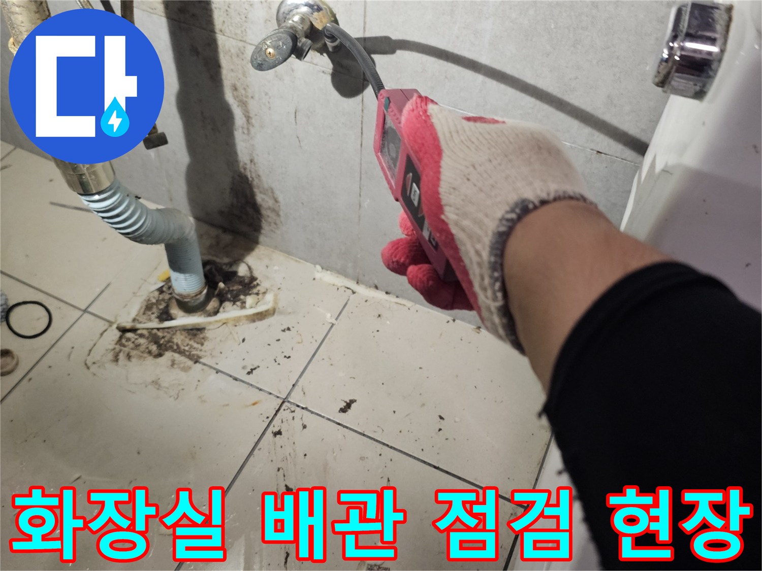 작업자가 장갑을 끼고 화장실 바닥의 노출된 배관 연결 부위를 확인하는 모습