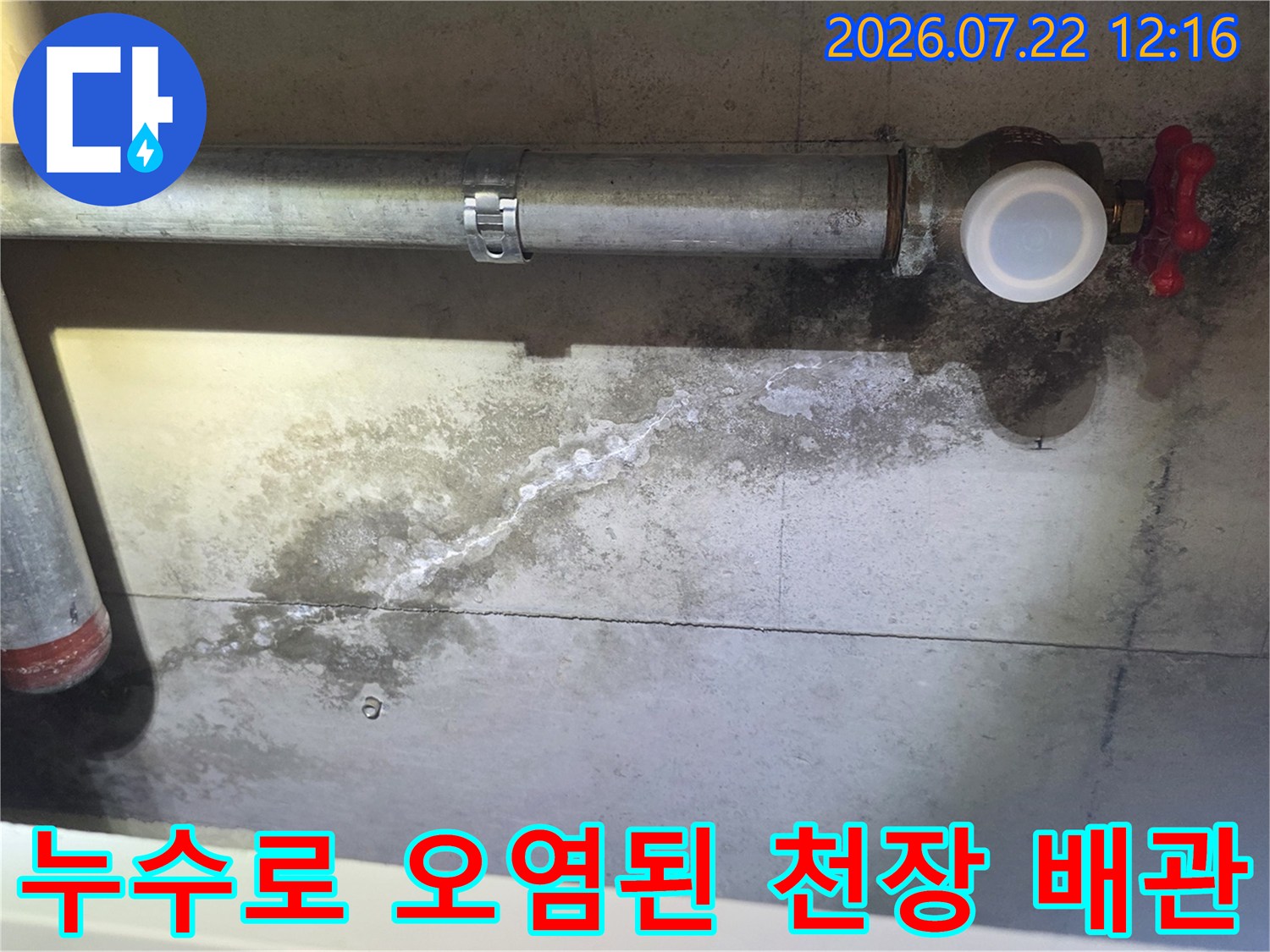 금속 파이프와 밸브 주변 콘크리트 벽면에 하얀 백화 현상과 물 얼룩이 퍼져 있는 사진