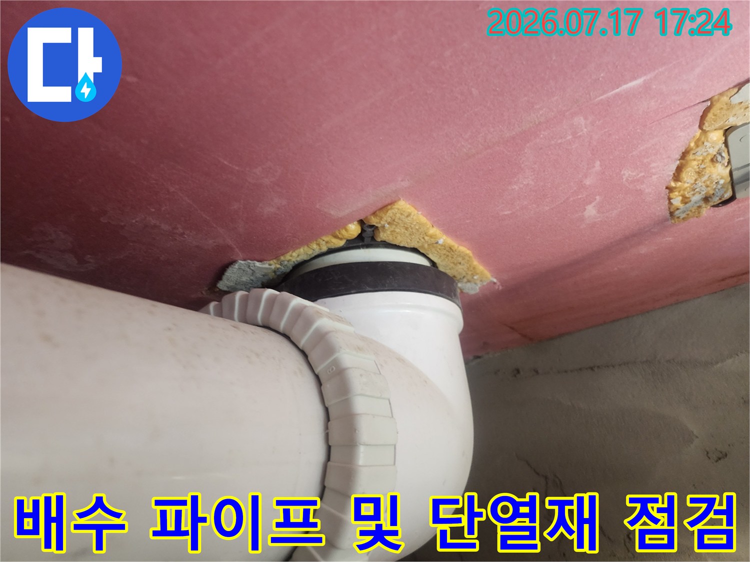 노란색 단열재와 흰색 배출구 파이프로 구성된 천장 내부 구조