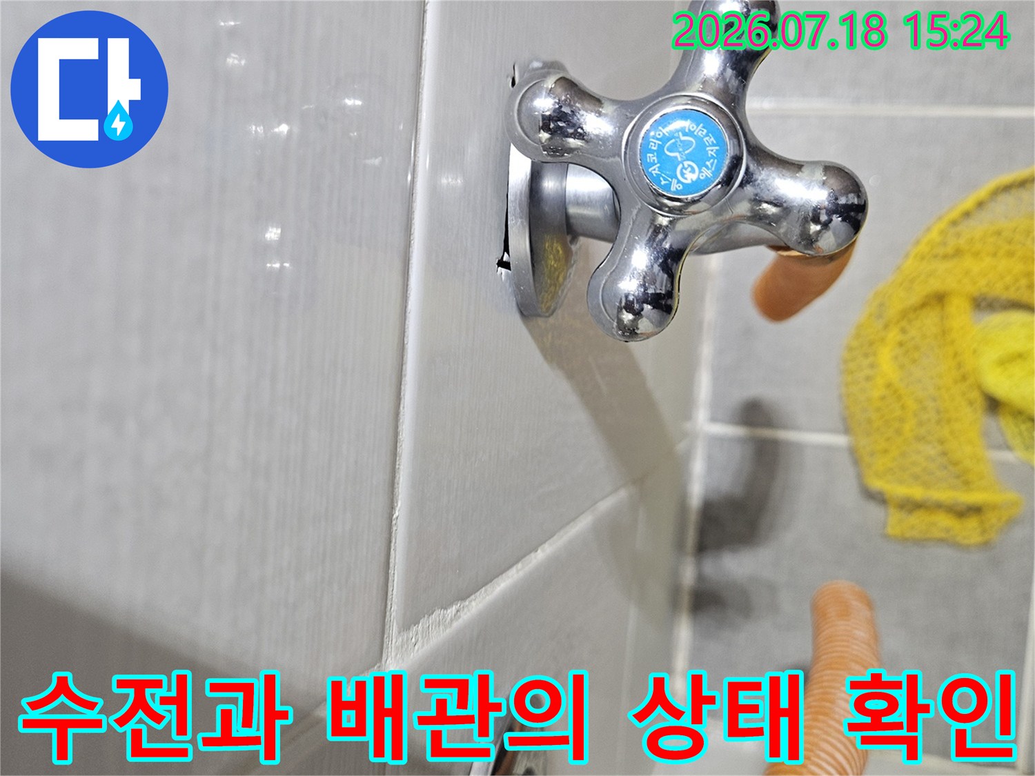 오렌지색 보온재로 감싼 배관 옆에 설치된 십자형 모양의 수전 구조물