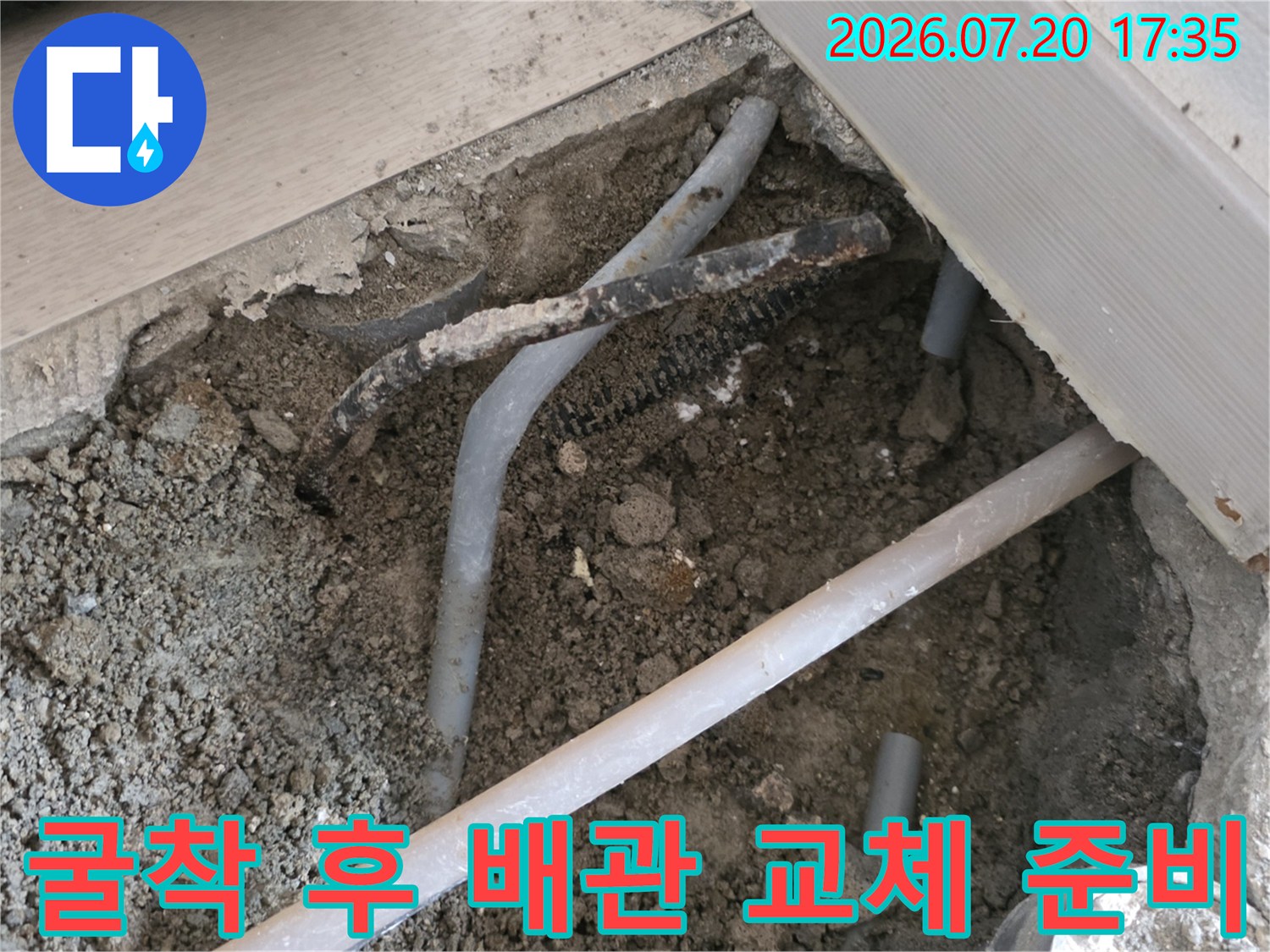터진 회색 배관을 절단하여 제거하고 새 연결부를 준비하는 현장