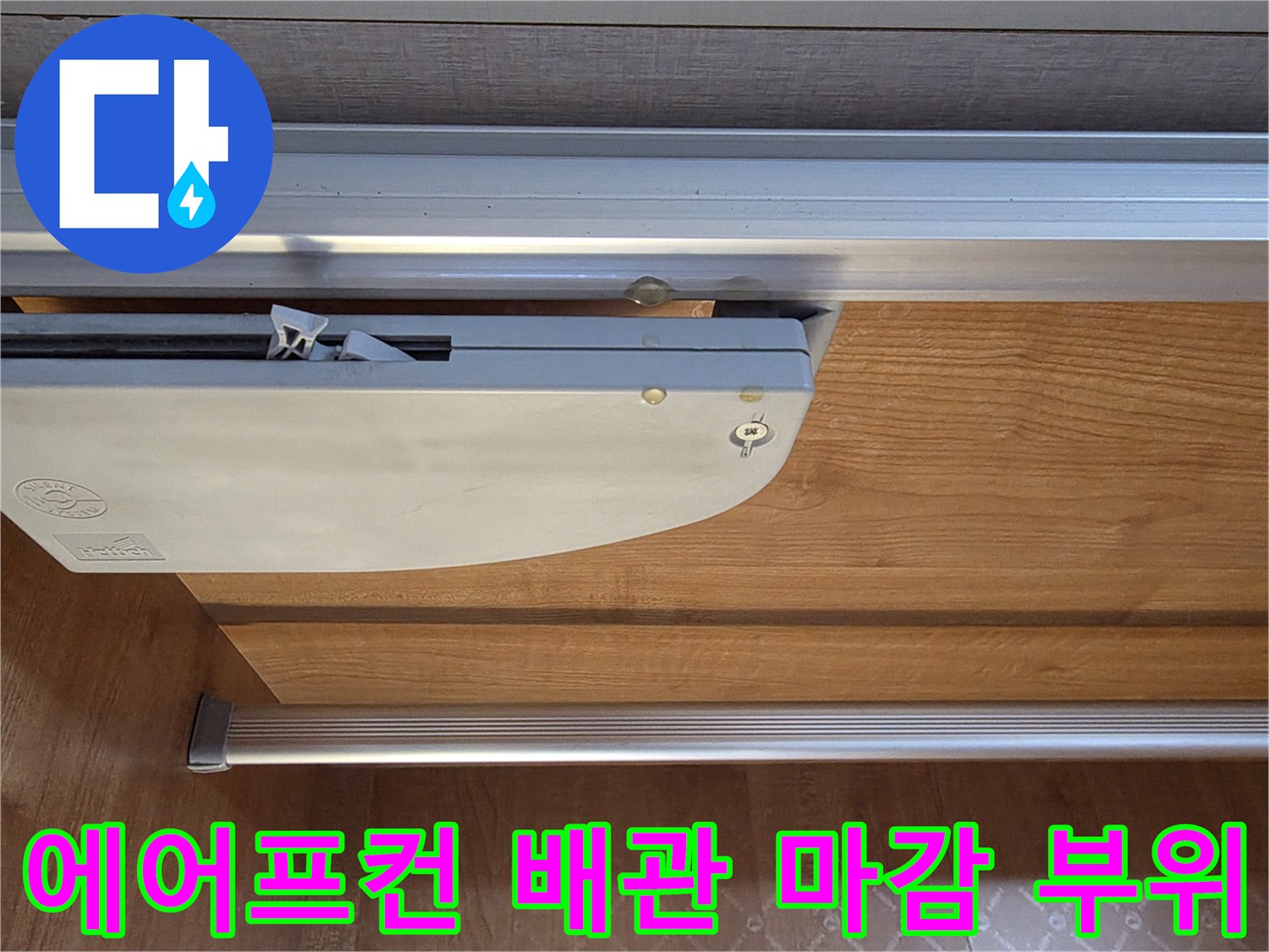 배관이 통과하는 알루미늄 프레임과 목재 마감 상세