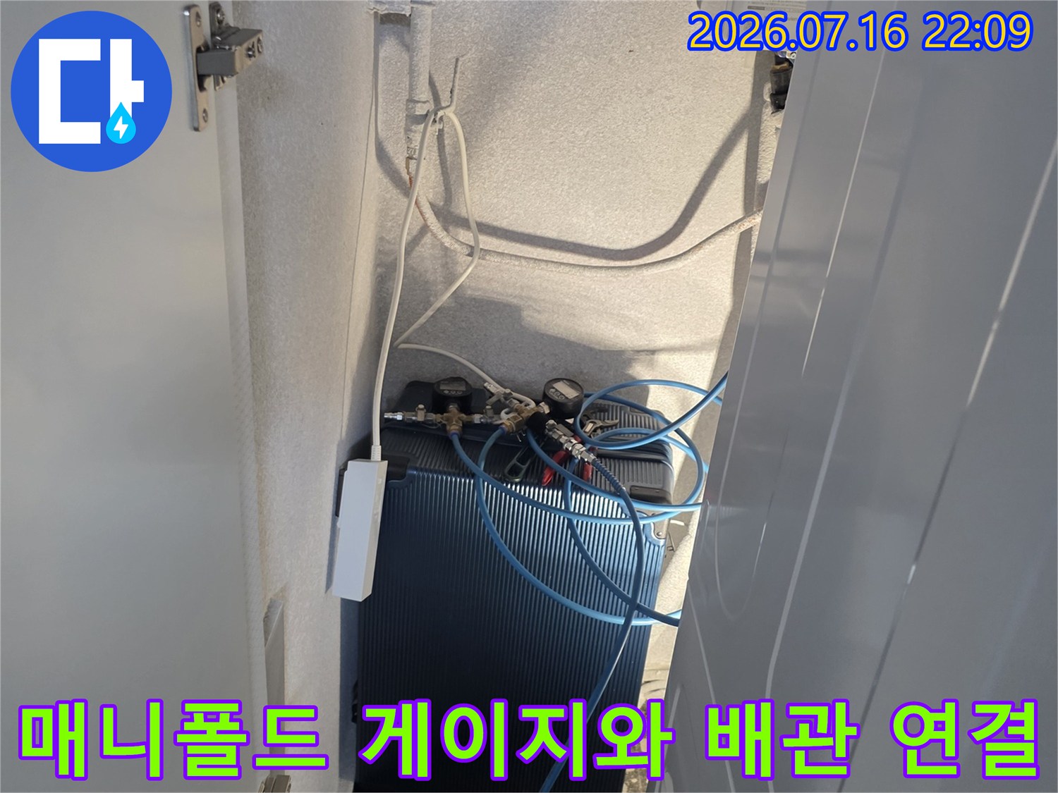 에어컨 시스템 배관과 매니폴드 게이지를 연결하여 가스 누설 여부를 체크하는 장면