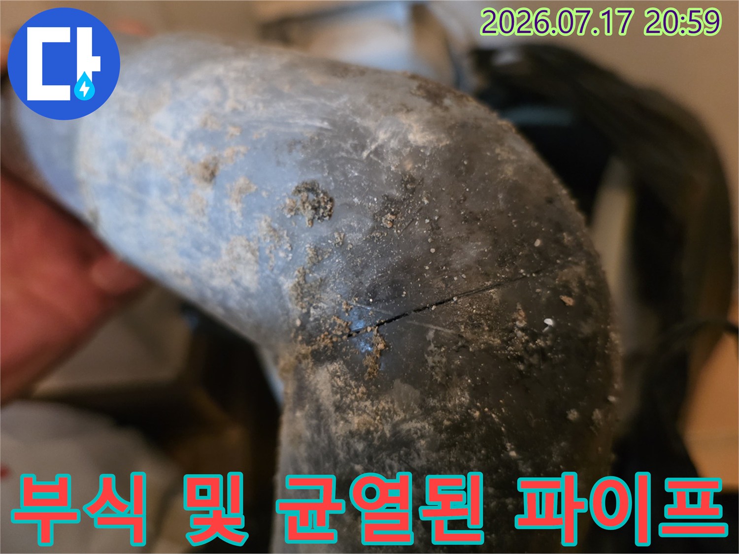 거친 질감과 균열을 동반한 노후 회색 배출용 엘보우 관