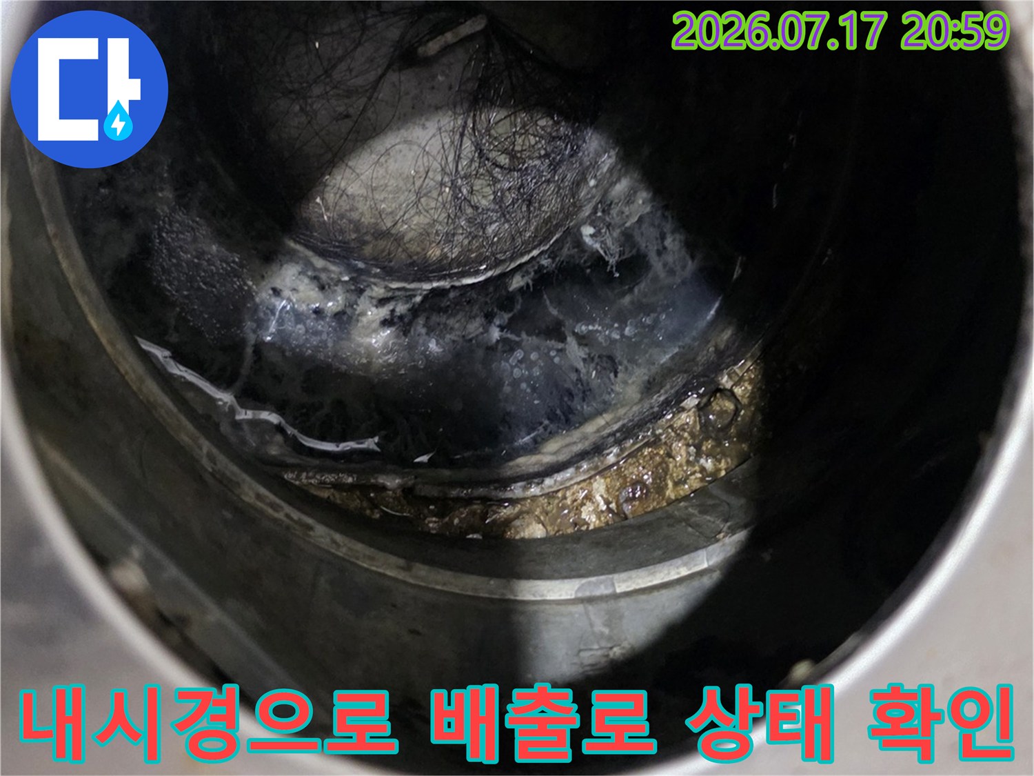 어두운 곳에서 내시경 장비를 활용해 싱크대 아래 배수관 내부를 정밀 점검하는 모습