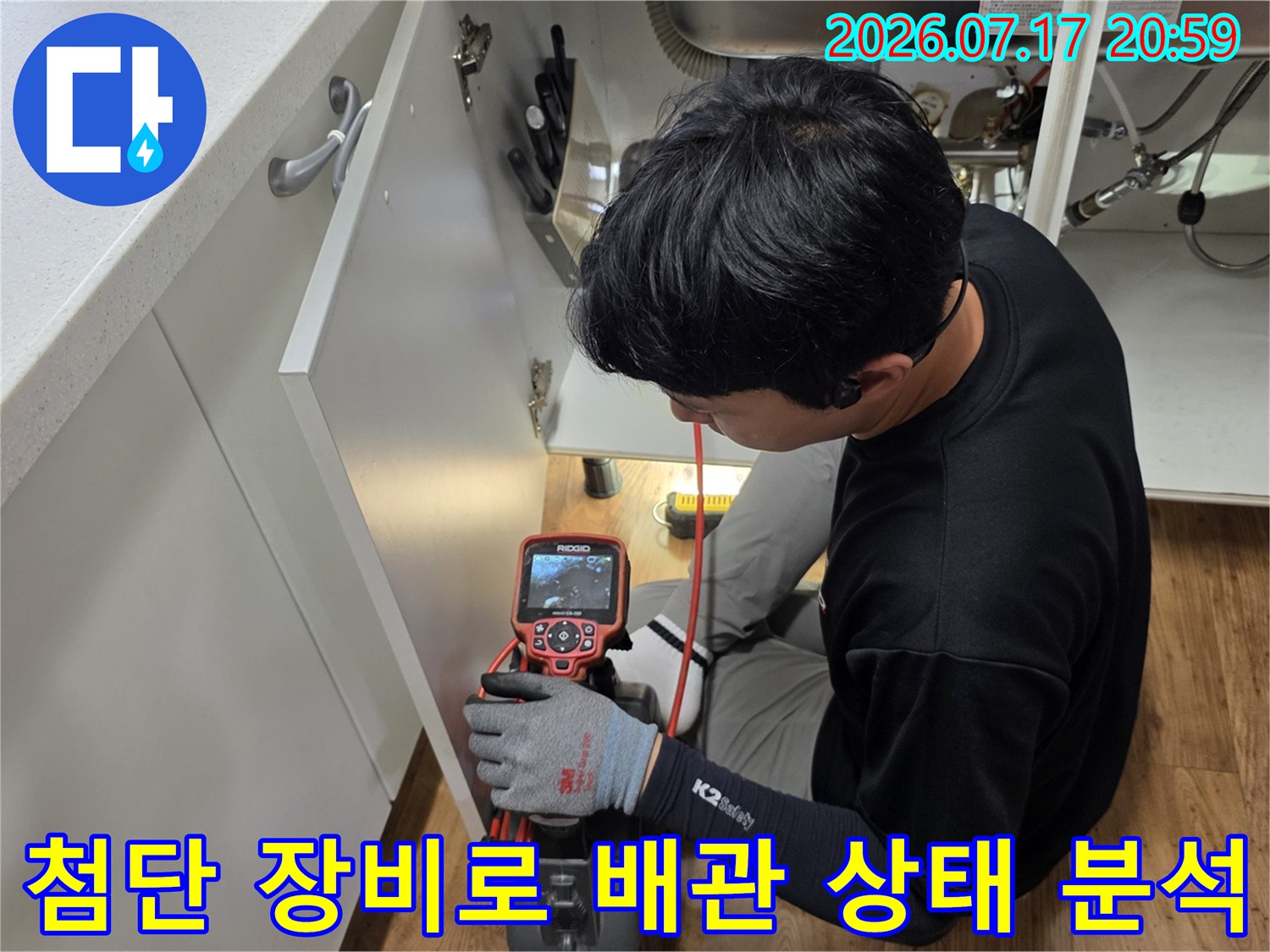 작업자가 전용 탐지기 화면을 확인하며 싱크대 하부의 매립된 배관 상태를 정밀 점검함