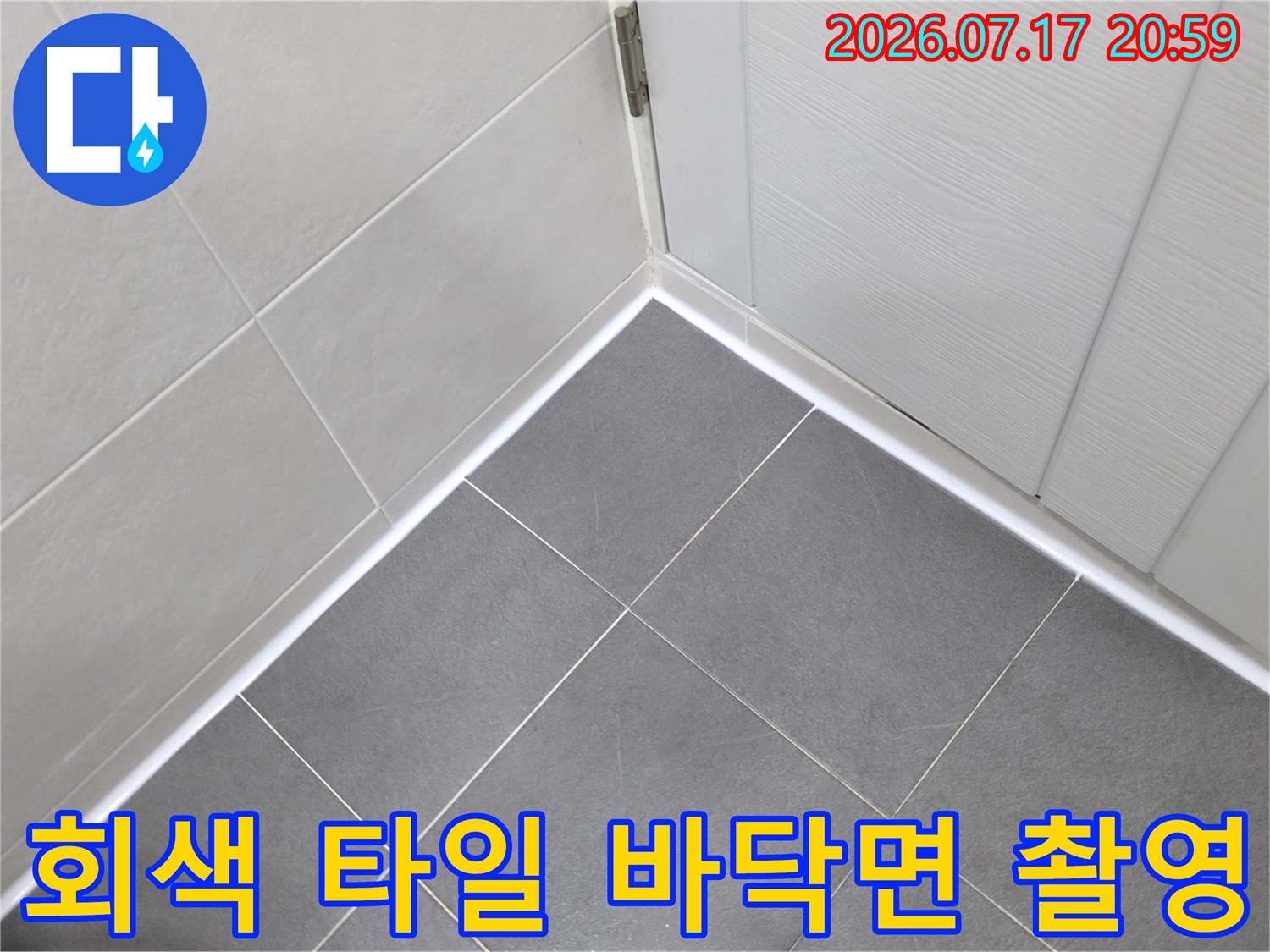 현관 진입로의 회색 타일과 벽체 접합부 상세 사진