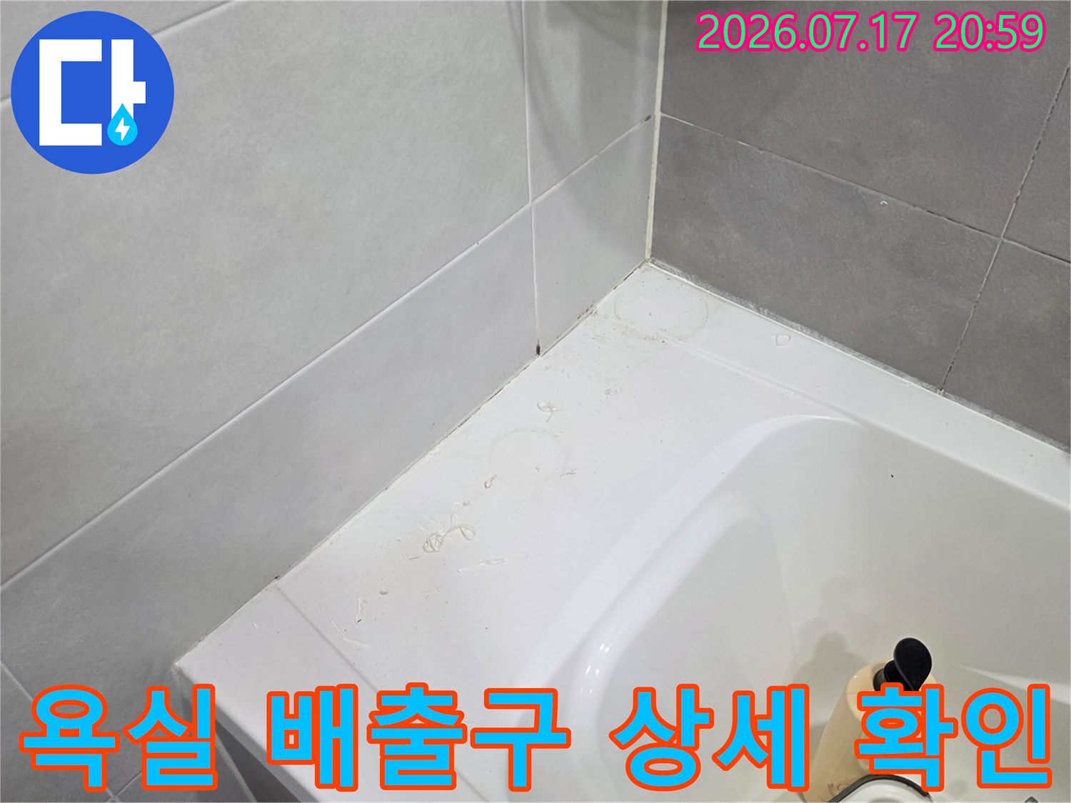 화장실 하부의 배수 트럼과 연결 부위에 대한 누수 진찰을 진행하는 모습