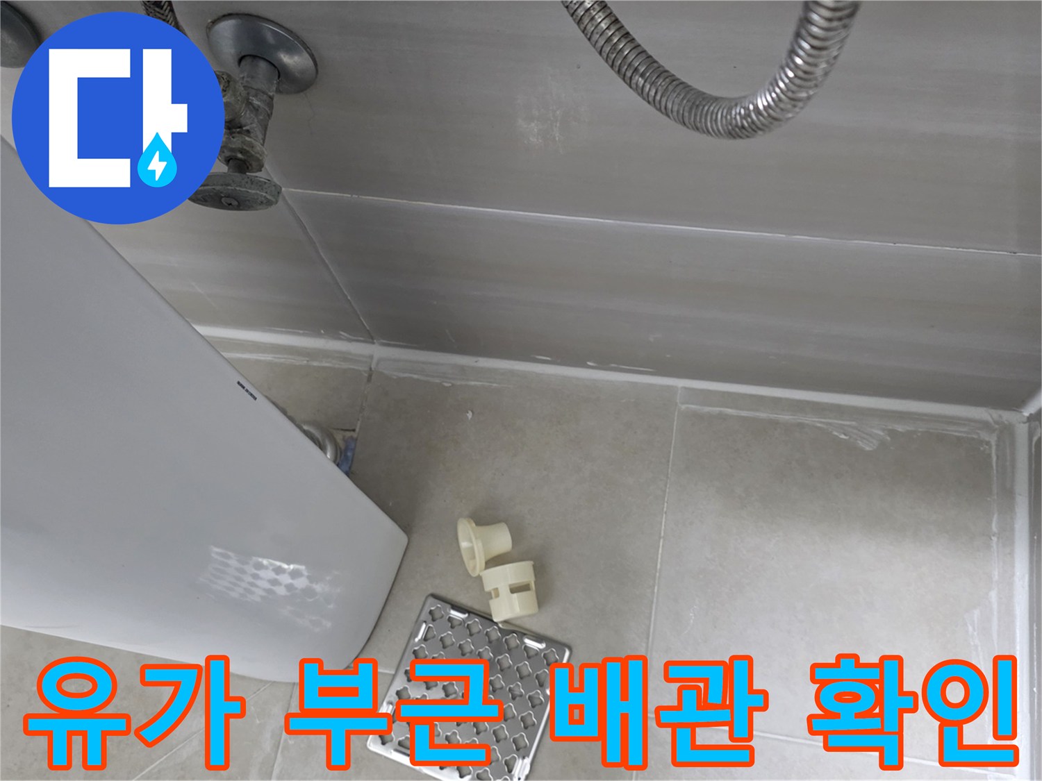 화장실 유가와 수전 배관 주변의 타일 마감 상태를 보여주는 이미지입니다.