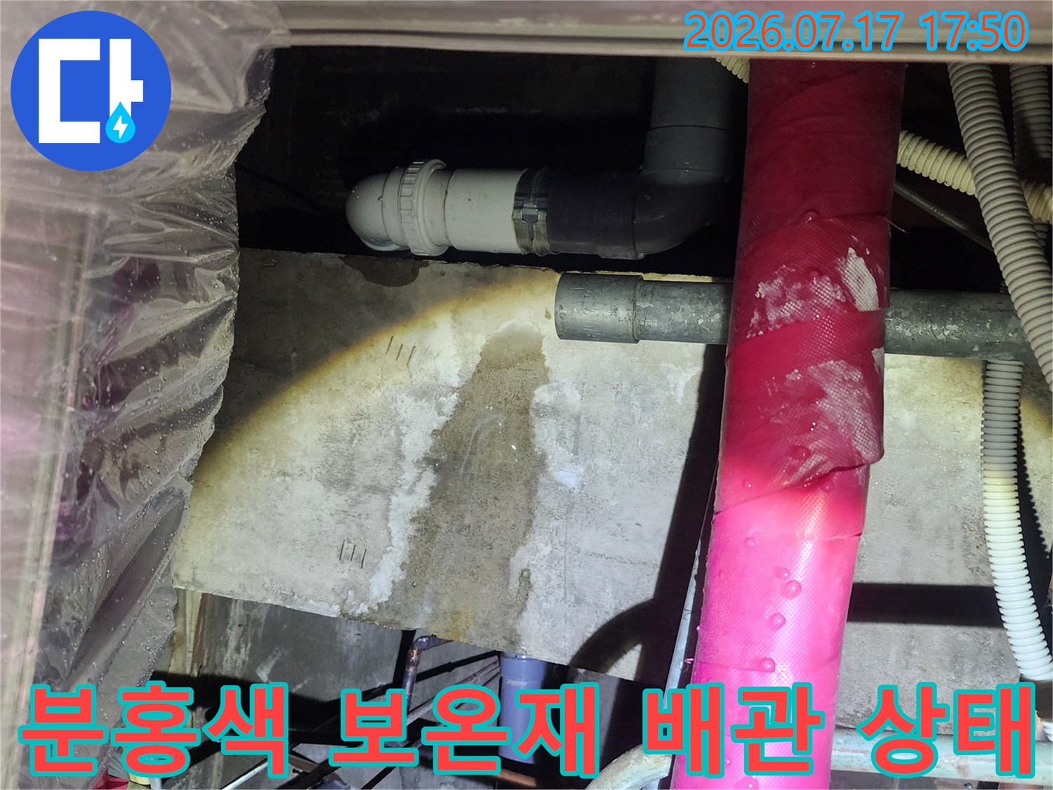 천장에 설치된 분홍색 보온재 마감 배관과 하단 회색 배수관-모습
