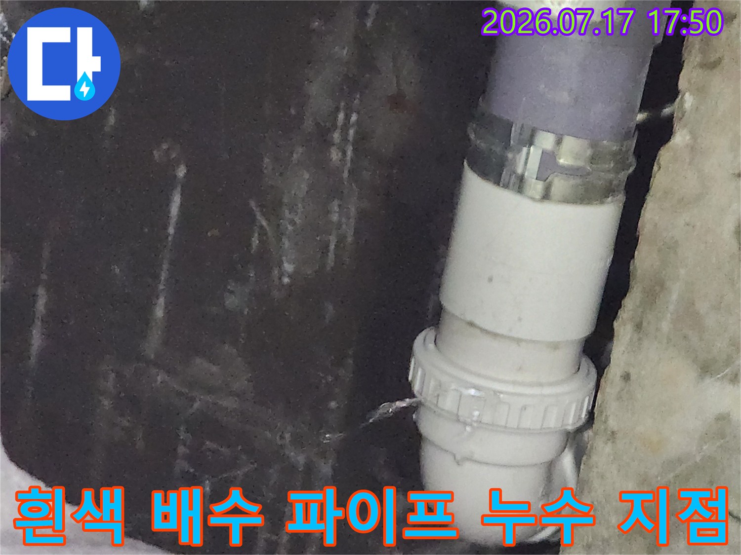 플라스틱 재질의 세면대 배수관 연결 부위에서 물이 새어 나오는 근접 사진