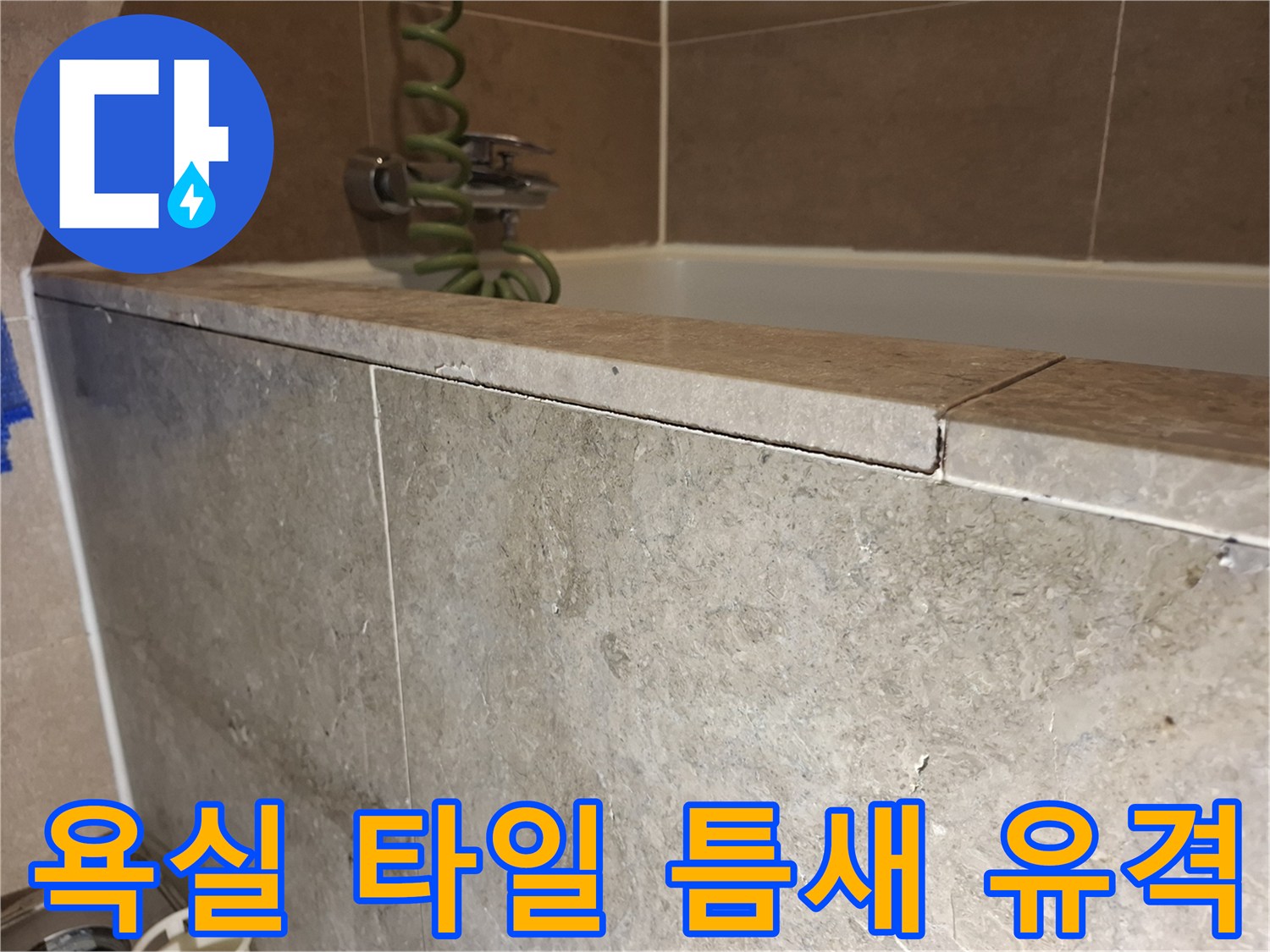 욕실 벽면-타일 경계와 샤워기 헤드 주변 상세 사진입니다.