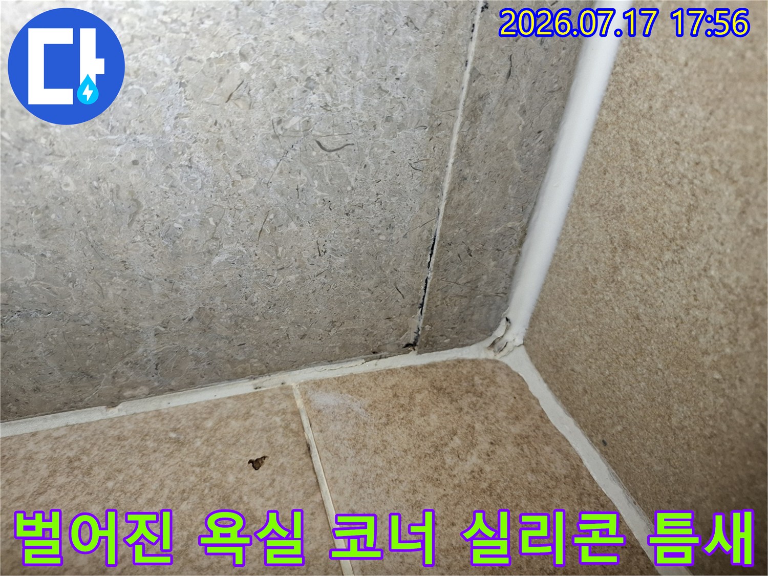 욕실 타일의 모서리 접합 부위 마감재가 노후되어 공간이 생긴 근접 촬영 사진