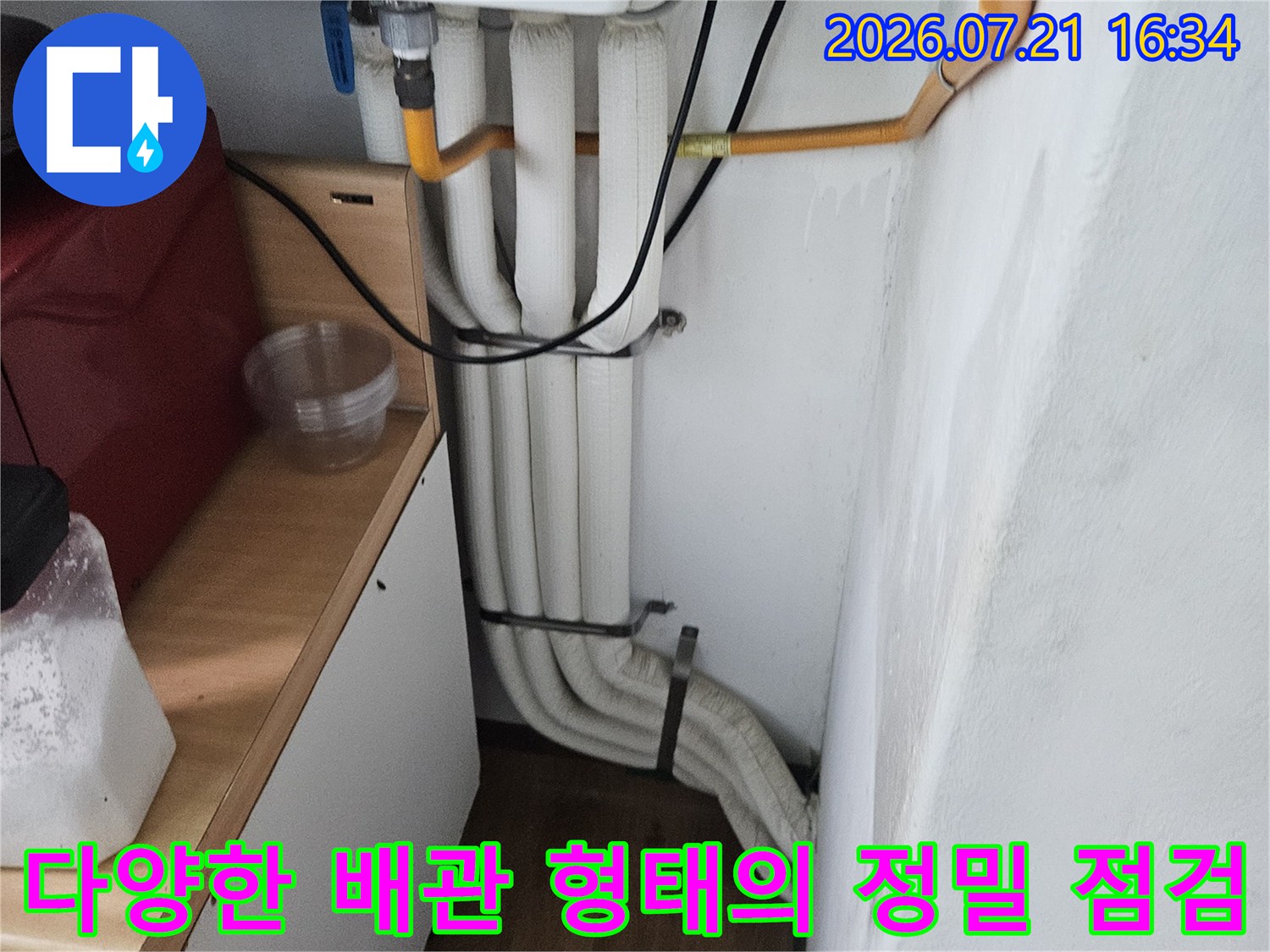 세면대 하부 공간에 설치된 흰색과 노란색 배관들의 구성